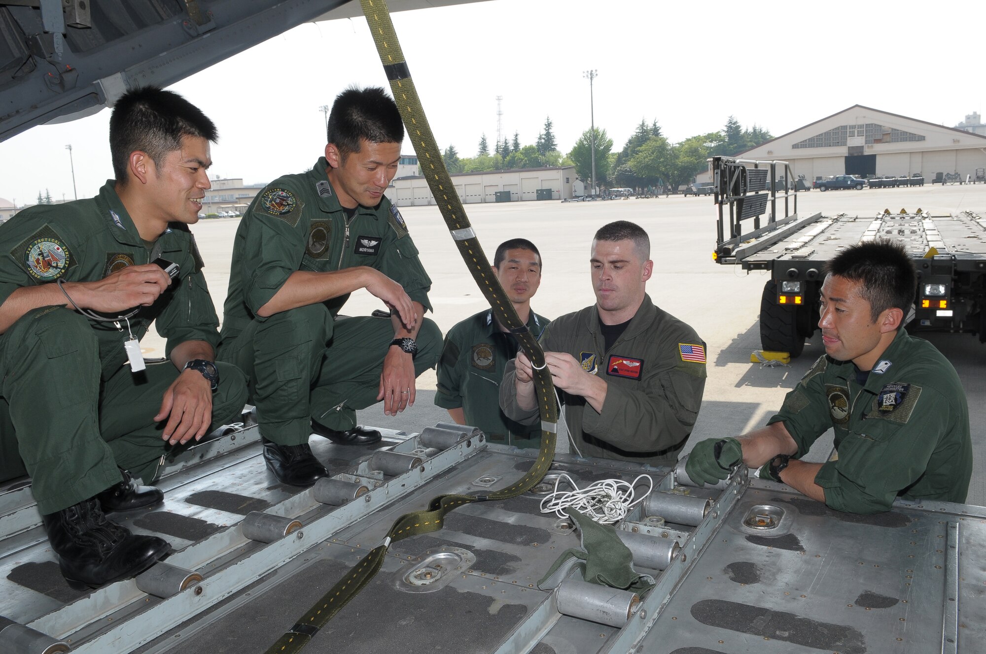 YOKOTA AIR BASE, Japan -- Staff Sgt. Ryan Gossen, 374th Operations Support Squadron loadmaster, demonstrates how to properly secure an extraction line May 5 during a Joint Air Delivery Inspection. The extraction line is used to pull cargo out of a C-130. (U.S. Air Force photo/Airman 1st Class Sean Martin)