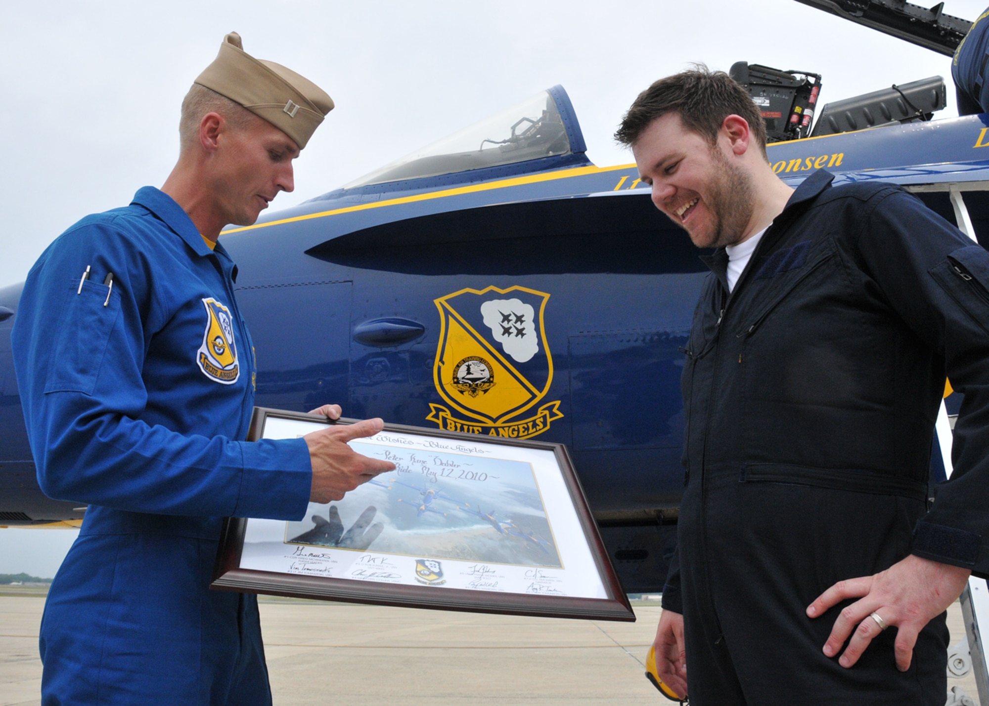 Navy Lt. C.J. Simonson, Blue Angels aircraft number 7 advance pilot, left, presents Kane, Hot 99.5 morning talk show host for “The Kane Show” on WIHT-FM Washington D.C., with an autographed image of a Blue Angels formation after his flight in a Navy F/A-18 Super Hornet on Joint Base Andrews, Md., flightline May 12. Kane flew with the Blue Angels as a special media guest prior to the Joint Service Open House May 14, 15 and 16. A total of three invitees, including key community leaders, flew with the Blue Angels out of Andrews. (U.S. Air Force photo by Airman 1st Class Kat Lynn Justen)