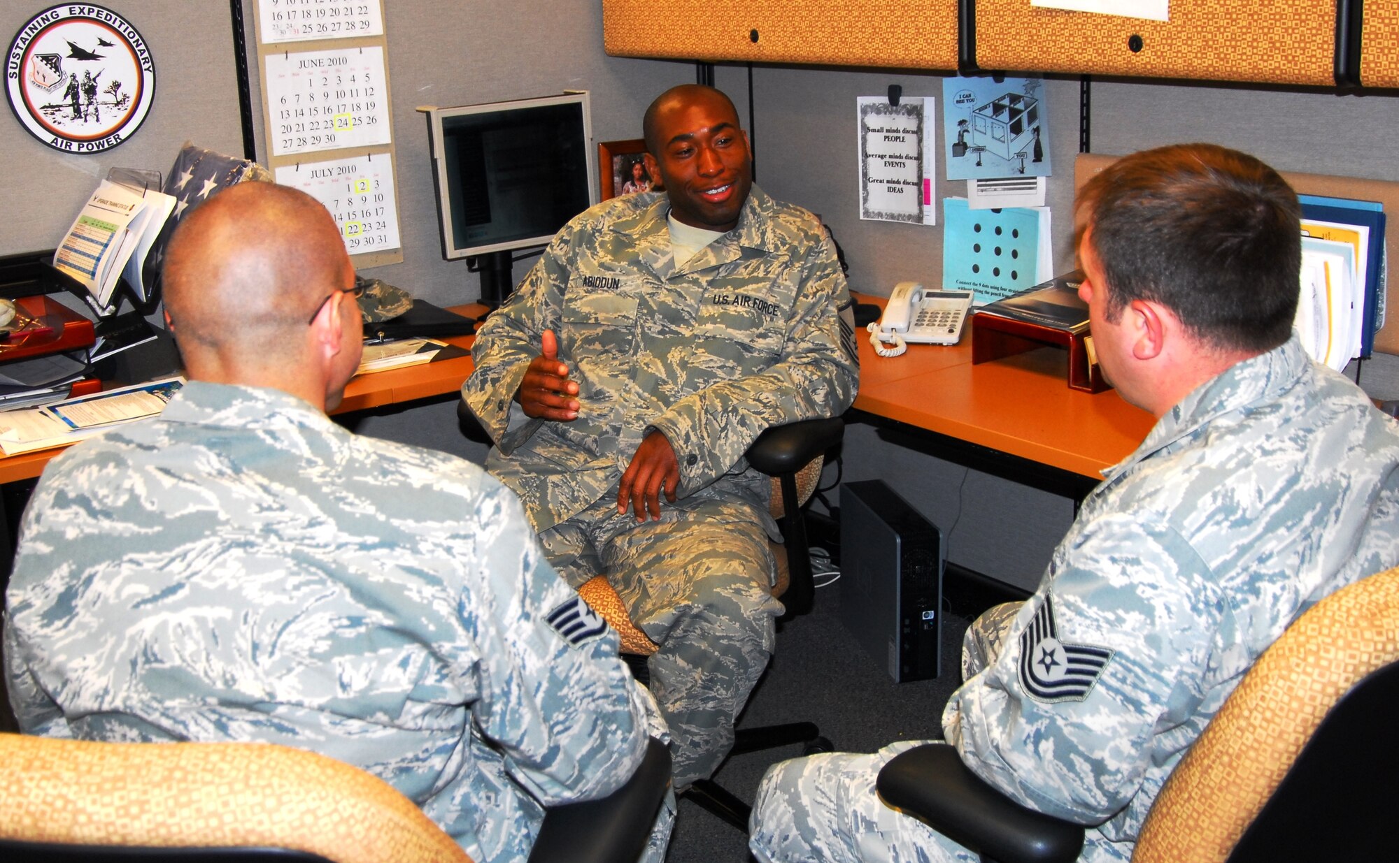 MSgt. Bo Abiodun mentors two junior colleagues as part of his daily routine as the 412th Test Wing, F-35 Plans and Scheduling non-commissioned officer-in-charge, here.  His leaderhisp ability was one of 13 character traits attributed to Seargeant Abiodun as he was named one of 10 Ten Outstanding Young Americans by the U.S. Junior Chamber. He will receive the award June 5 in New Orleans, La.  Air Force photograph by Stephen K. Robinson
