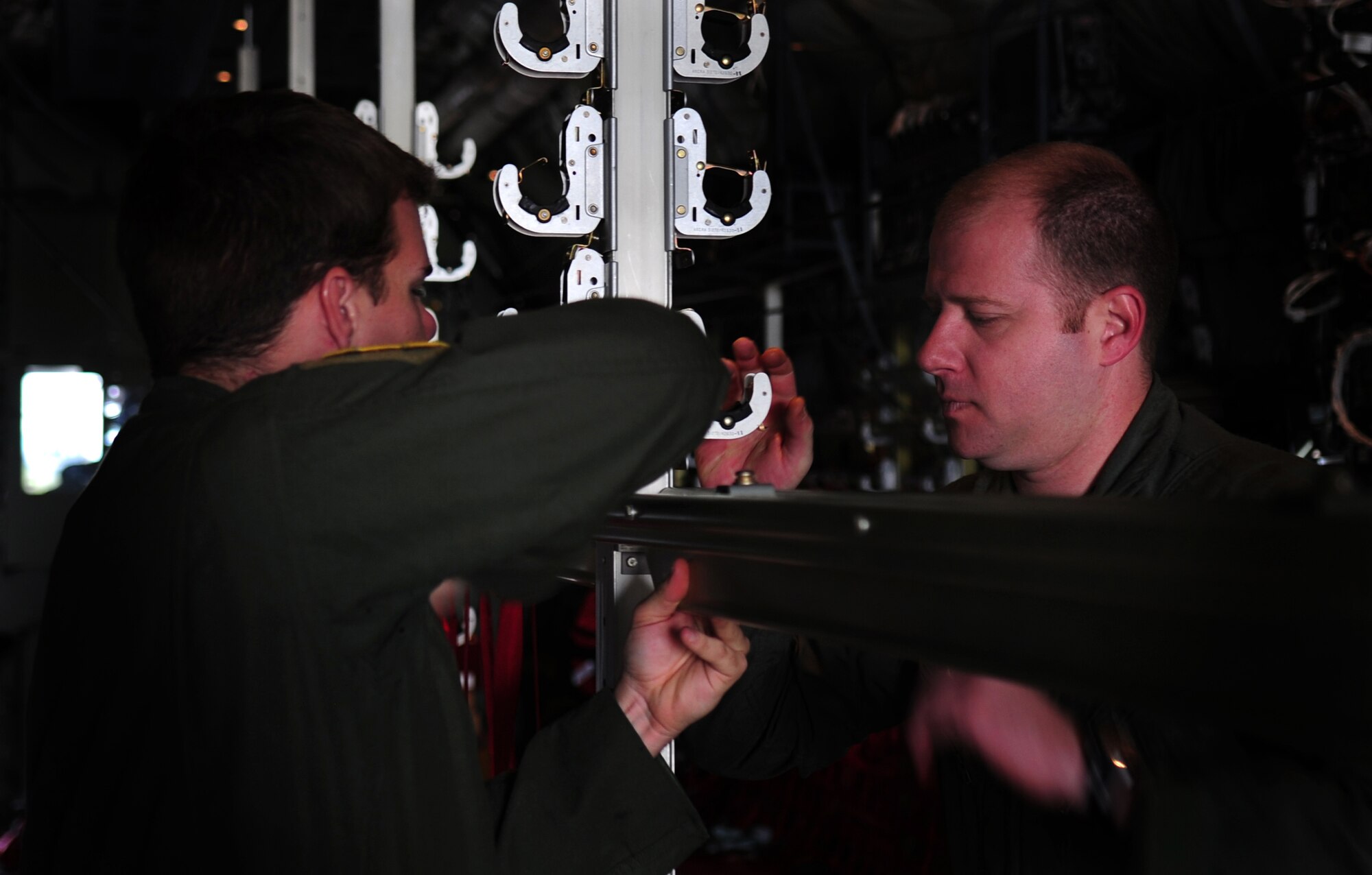 U.S. Air Force Staff Sgt. Brett Hunter and Tech. Sgt. Scott Schlup, 37th Airlift Squadron loadmasters, assemble additional jump seats in a C-130J in preparation of Romanian Air Force members for a paratroop jump during the joint exercise Carpathian Summer, Otopeni Airlift Base, Romania, May 12, 2010. Carpathian Summer 2010 was an exercise in which the Romanian Air Force invited members of the U.S. military to train with them on their soil and air space, to observe and practice, firsthand, operations in action. This exercise was designed to build partnerships between these nations in an effort to work together more efficiently during real world scenarios. (U.S. Air Force Photo by Staff Sgt. Jocelyn Rich)