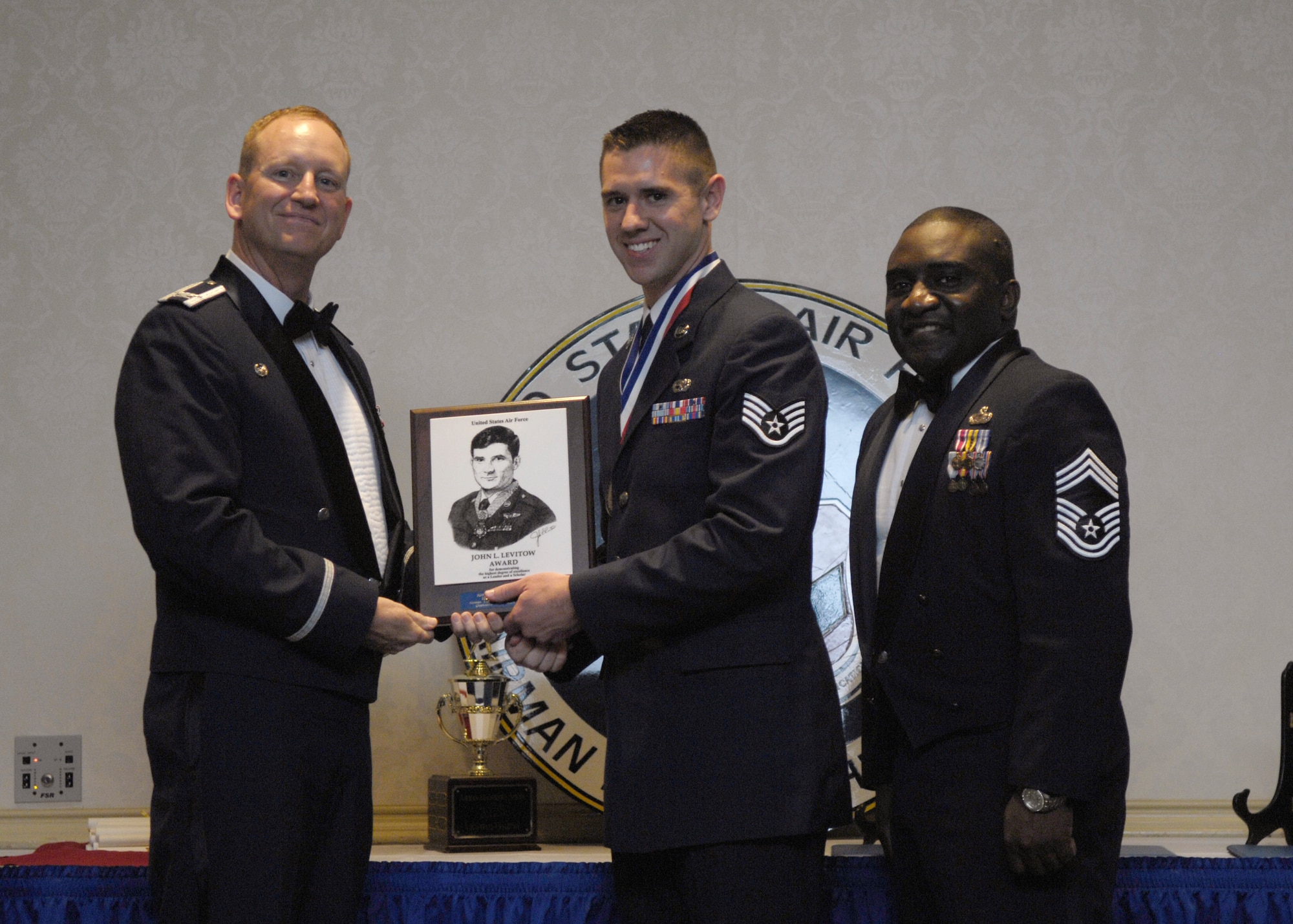 Col. Benjamin Wham, left, and Chief Master Sgt. Thomas Jackson, right, present Staff Sgt. Jonathan Houghton with the John L. Levitow Award during the Airman Leadership School Class 10-D graduation at the Charleston Club here May 6, 2010. The award is given for a student's exemplary demonstration of excellence both as a leader and a scholar. Colonel Wham is the 628th Mission Support Group commander, Chief Jackson is the 628th Mission Support Group command chief and Sergeant Houghton is a Communication, Navigation, Mission Systems Journeyman with the 437th Aircraft Maintenance Squadron on loan to the 628th Air Base Wing protocol office. (U.S. Air Force Photo/Airman 1st Class Lauren Main)
