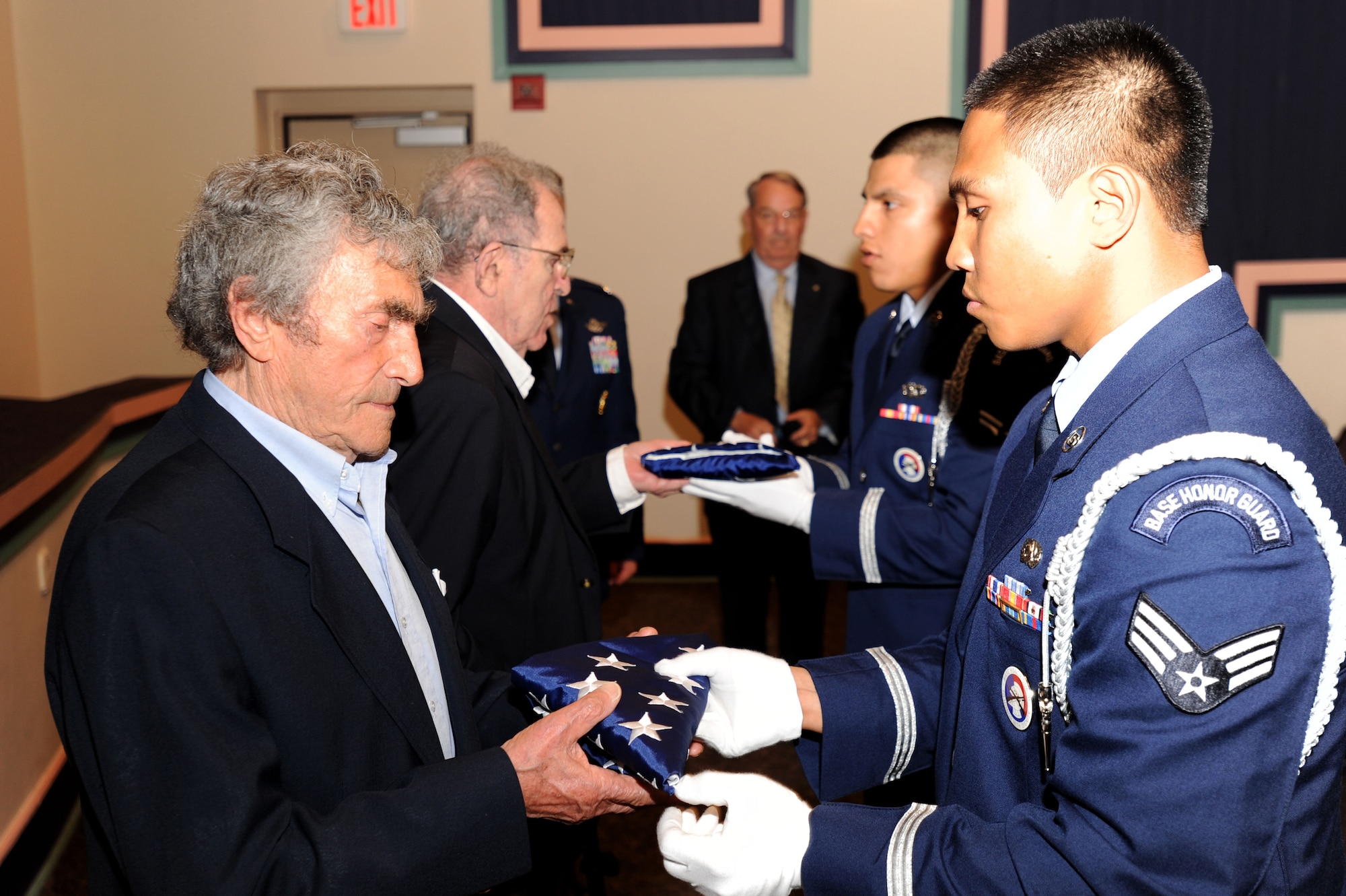 Holocaust survivors Herman Snyder (foreground) and Dr. Victor Sapio receive flags, flown over our Nation's Capitol from Hurlburt Field Honor Guard Members Senior Airman Ephraim Gill (foreground) and Airman 1st Class Gabriel Pillcurima. Congressman Jeff Miller provided the flags and certificates of appreciation for Hurlburt Field's Annual Holocaust Remembrance Ceremony May 4. Helen Hunt Rigdon represented the Congressman during the ceremony. The event was hosted by the 505th CCW on behalf of the 1st Special Operations Wing. The theme of this year's observance is "Stories of Freedom: What You Do Matters." (U.S. Air Force Photo by Senior Airman Matthew R. Loken)
