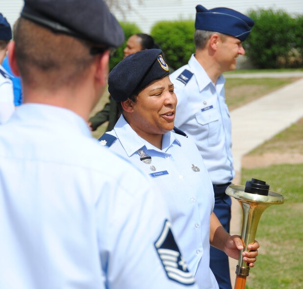Lt. Col. Michelle Stringer, commander of the 71st Security Forces Squadron holds the torch after the finish of a 98-mile torch run in celebration of National Police Week. (U.S. Air Force photo/ Ensign Rex Miller)