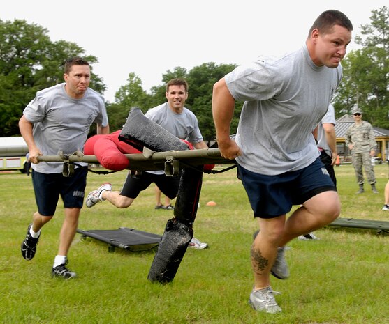 U.S. Navy MA1 Jacob Moore and U.S. Navy MA2 Nicholas Green carry a litter during a relay race at the second annual Guns vs. Hoses competition held on Joint Base Charleston, S.C., May 10, 2010. This event was one of many in which the 628th Security Forces Squadron and the 628th Civil Engineer Squadron competed against each other. Other events that took place included a push-up and sit-up competition as well as a tug o' war. MA1 Moore and MA2 Green are with the Naval Weapons Station Security Department. (U.S. Air Force Photo/Airman 1st Class Lauren Main)