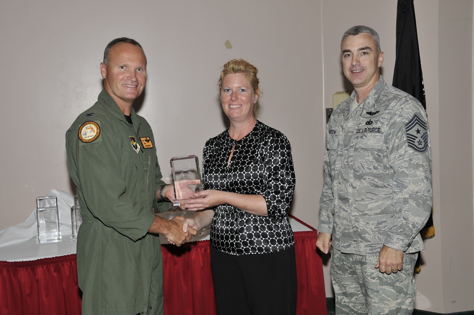 Colonel James Browne, 325th Fighter Wing commander, presents Ms. Victoria Weiss, 53rd Test Support Squadron section commander secretary, the Associate Unit Civilian Category I of the Quarter award, as Chief Master Sgt. Jackie Greene, 325th FW command chief, looks on.

