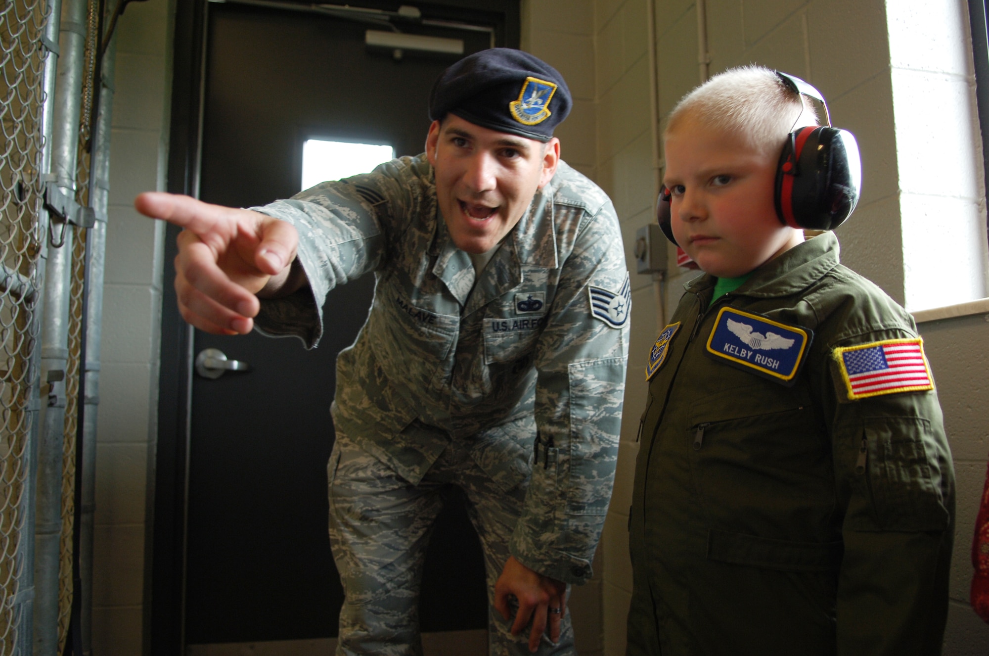 SCOTT AIR FORCE BASE, Ill. -- Staff Sgt. Jason Malave, 375th Security Forces Squadron military working dog trainer, shows Kelby the MWD dogs here at Scott AFB before a MWD demonstration. (U.S. Air Force photo by Senior Airman Ryan Crane)