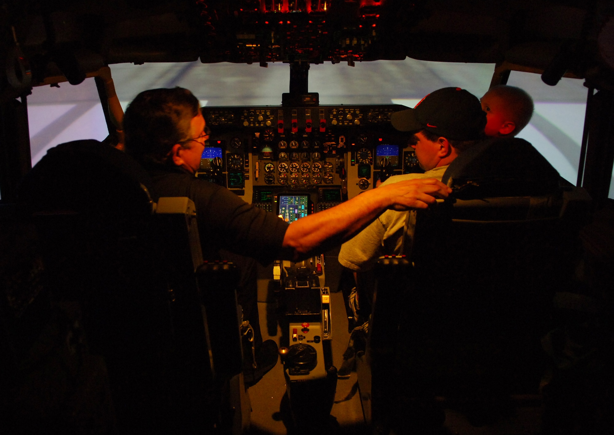 005 SCOTT AIR FORCE BASE, Ill. -- Kelby and his father, Shaun, are shown how to use the KC-135 simulator before handing the controls to Kelby. During the simulation, Kelby flew over the Pacific Ocean and successfully landed the plane. (U.S. Air Force photo by Senior Airman Ryan Crane)