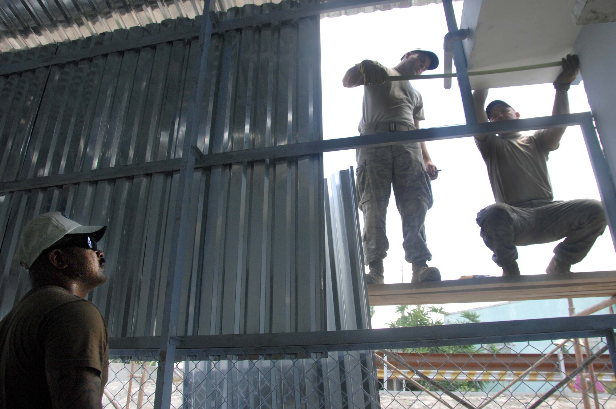 U.S. Navy Petty Officer 1st Class James Marquez (left) and U.S. Air Force Senior Airman Cary Abernathy, and Senior Airman Aaron Walsen, civil engineers with the engineering civil assistance program for Pacific Angel 2010, make final measurements before installing sheet metal that will act as a rain shield for the Tan Toi Village Elementry School medical clinic in Can Tho, Vietnam, during the mission on May 12, 2010.  Operation Pacific Angel is a joint and combined humanitarian and civic assistance operation conducted in the Pacific area of responsibility to support U.S. Pacific Command's capacity-building efforts.
More than 50 U.S. military members are working alongside the Vietnamese military, non-governmental organizations and civil health personnel in medical and engineering efforts during the mission scheduled through May 15. (U.S. Air Force photo/ Capt. Timothy Lundberg)