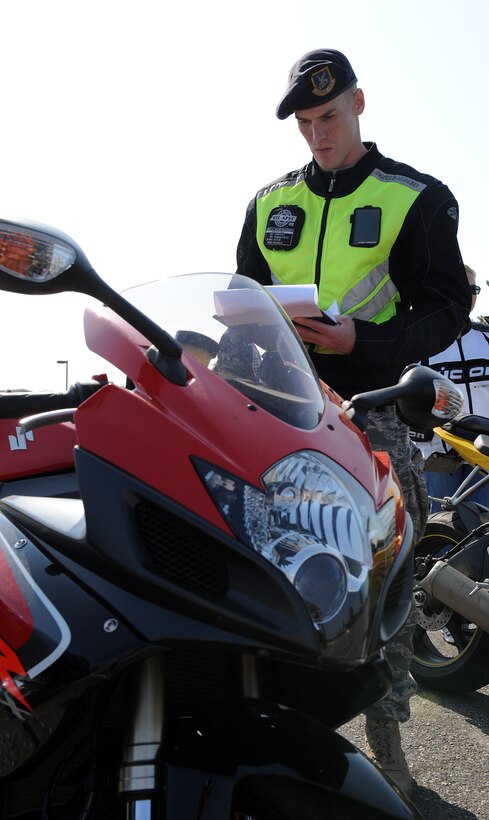 LANGLEY AIR FORCE BASE, Va. -- Staff Sgt. Brandon Phelps, 633d Security Forces unit training instructor,  inspects a motorcycle before the ride  May 12. The ride was part of National Police week to remember the brave police officers who have fallen to protect us at home. (U.S. Air Force photo/Senior Airman Zachary Wolf)