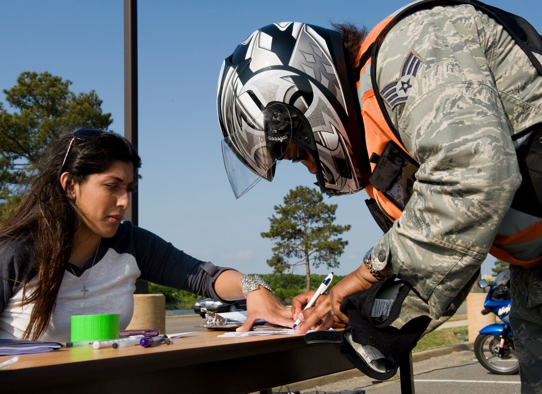 LANGLEY AIR FORCE BASE, Va. -- Airman Stephanie Miller, 633d Security Forces Squadron operations bravo flight member, holds the paper down as Staff Sgt. Adrienne Faircloth, 633d Security Forces Squadron patrolman, registers. The ride was part of National Police Week, a celebration in honor of law enforcement officers who lost their lives in the line of duty. (U.S. Air Force photo/Senior Airman Zachary Wolf)
