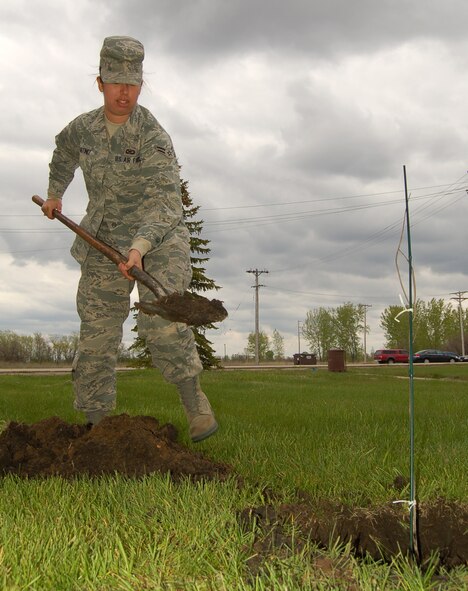 Airman 1st Class Rachel Martinez, 319th Air Refueling Wing Public Affairs, shovels dirt to cover the roots of a newly planted red oak tree May 12. The tree was donated to Grand Forks Air Force Base from the Air Force Real Property Agency as part of their “Trees Across America” campaign in celebration of the 40th Anniversary of Earth Day. Forty Air Force bases across the country planted trees in conjunction with this campaign.  (U.S. Air Force photo by Staff Sgt. R. Michael Longoria)