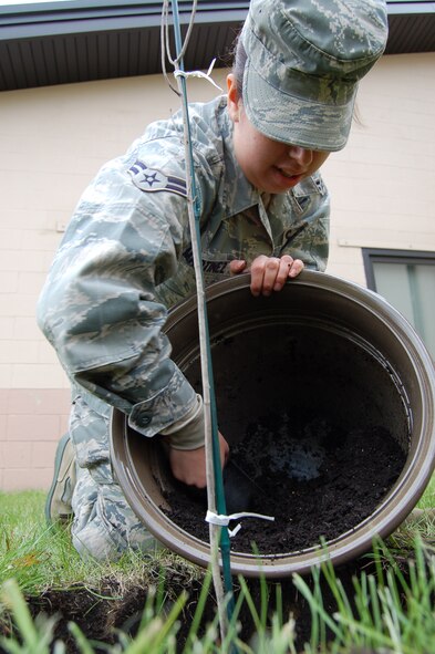 Airman 1st Class Rachel Martinez, 319th Air Refueling Wing Public Affairs, scoops dirt around a newly planted red oak tree May 12. The tree was donated to Grand Forks Air Force Base from the Air Force Real Property Agency as part of their “Trees Across America” campaign in celebration of the 40th Anniversary of Earth Day. Forty Air Force bases across the country planted trees in conjunction with this campaign.  (U.S. Air Force photo by Staff Sgt. R. Michael Longoria)