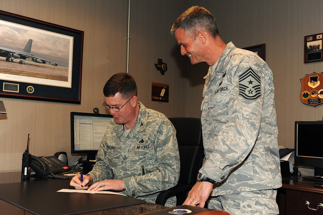 LANGLEY AIR FORCE BASE, Va. - Col. Donald Kirkland, 633d Air Base Wing commander signs an Air Force Assistance Fund donation form as Chief Master Sgt. Charles Anderson, 633 ABW command chief, looks on May 11. The AFAF campaign has benefited active duty, reserve, guard and retired Air Force personnel, surviving spouses and families. This year's campaign runs until May 20. (U.S. Air Force photo/Airman 1st Class Gul Crockett)