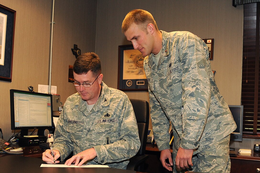 LANGLEY AIR FORCE BASE, Va. -- Col. Donald Kirkland, 633d Air Base Wing commander, signs an Air Force Assistance Fund donation form 2nd Lt. Kenneth Eaton, 633d Comptroller Squadron finance officer, looks on May 11. The AFAF campaign benefits active duty, reserve, guard and retired Air Force personnel, surviving spouses and families. This year's campaign runs until May 20. (U.S. Air Force photo/Airman 1st Class Gul Crockett)