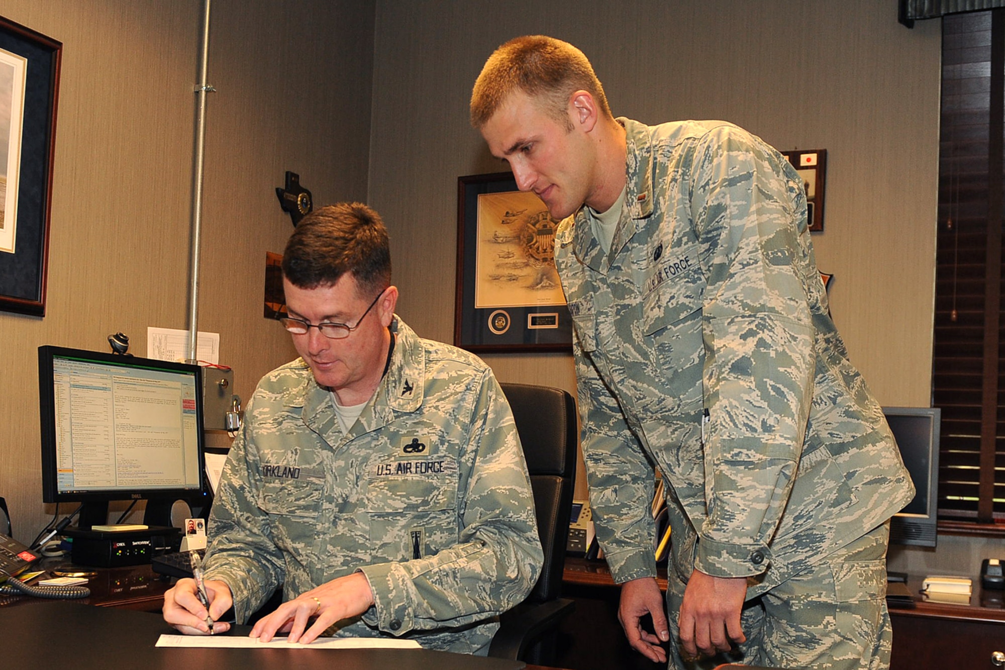 LANGLEY AIR FORCE BASE, Va. -- Col. Donald Kirkland, 633d Air Base Wing commander, signs an Air Force Assistance Fund donation form 2nd Lt. Kenneth Eaton, 633d Comptroller Squadron finance officer, looks on May 11. The AFAF campaign benefits active duty, reserve, guard and retired Air Force personnel, surviving spouses and families. This year's campaign runs until May 20. (U.S. Air Force photo/Airman 1st Class Gul Crockett)