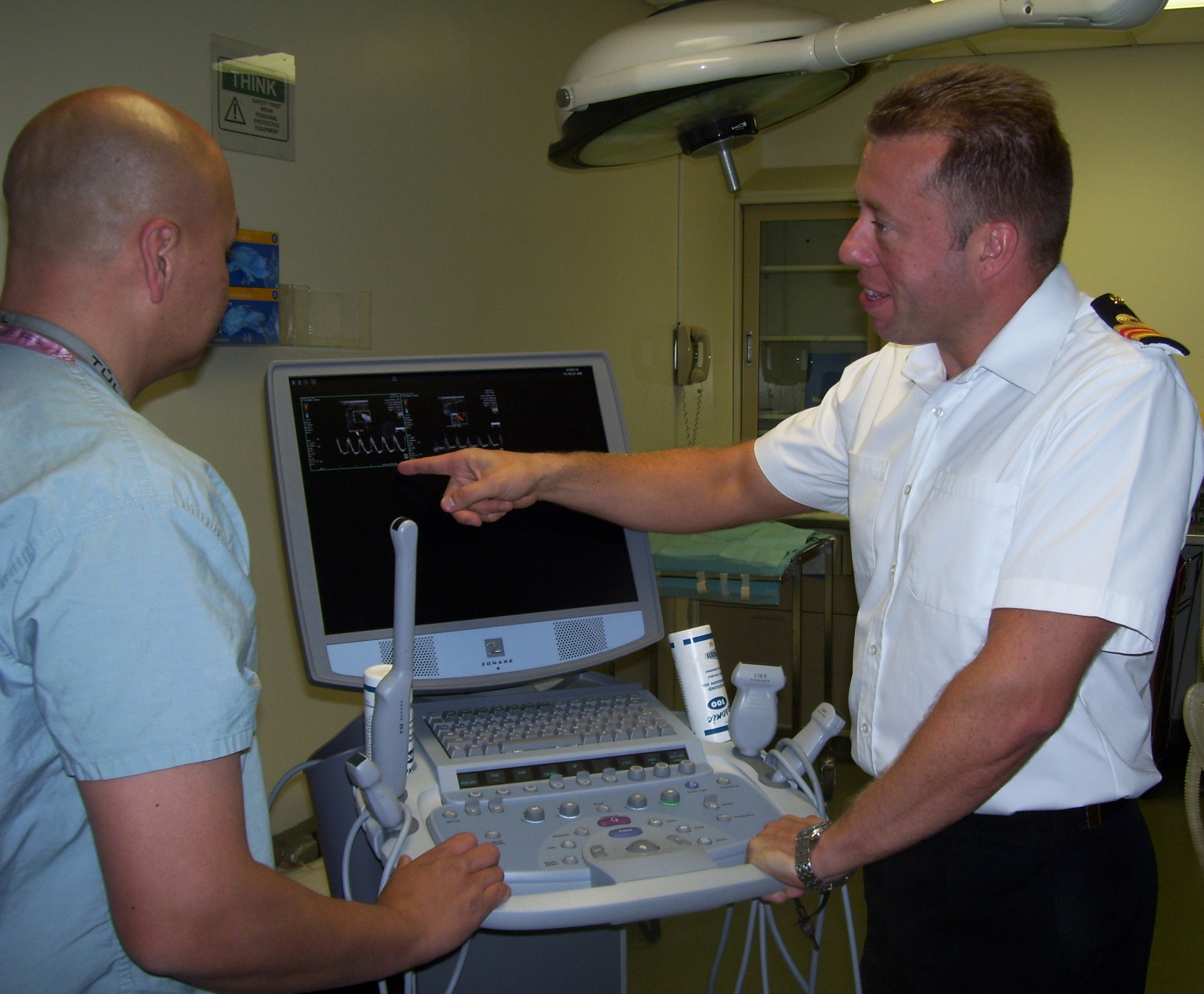 Surgeon Lt. Commander Adam Stannard, Royal Navy (right), discusses blood flow on an ultrasound machine with Mike Goedecke, biological lab assistant, in the Clinical Research building, Lackland Air Force Base, Texas, May 6. Commander Stannard, a fellow in the Academic Department of Military Surgery and Trauma, Royal Centre for Defence Medicine, Birmingham, U.K., has joined a 59th Medical Wing research team for one year to investigate vascular surgery techniques following battlefield trauma.