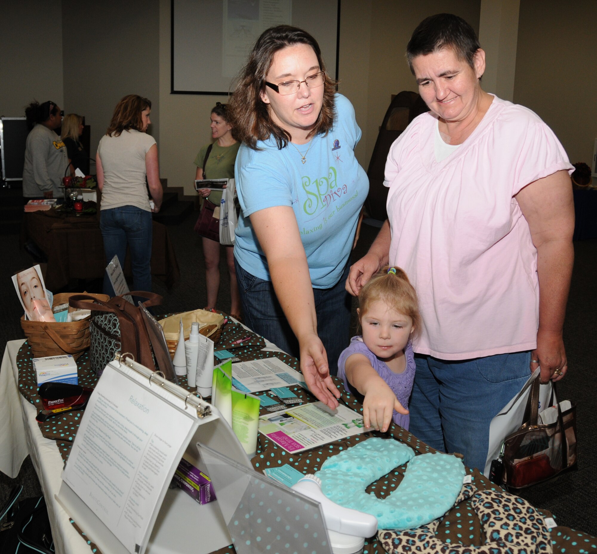 Kelley Stephenson, left, a Beauti Control consultant, shows products to Threasa Tuggle and her 4-year-old granddaughter, April Tuggle, during Pamper Me Day, May 7 at the Roberts Consolidated Aircraft Maintenance Facility.  Mrs. Tuggle is married to Tech. Sgt. James Tuggle, 81st Force Support Squadron.  The annual event sponsored by the airman and family readiness center featured agencies, vendors, giveaways, activities, business and product displays and information booths.  (U.S. Air Force photo by Kemberly Groue)