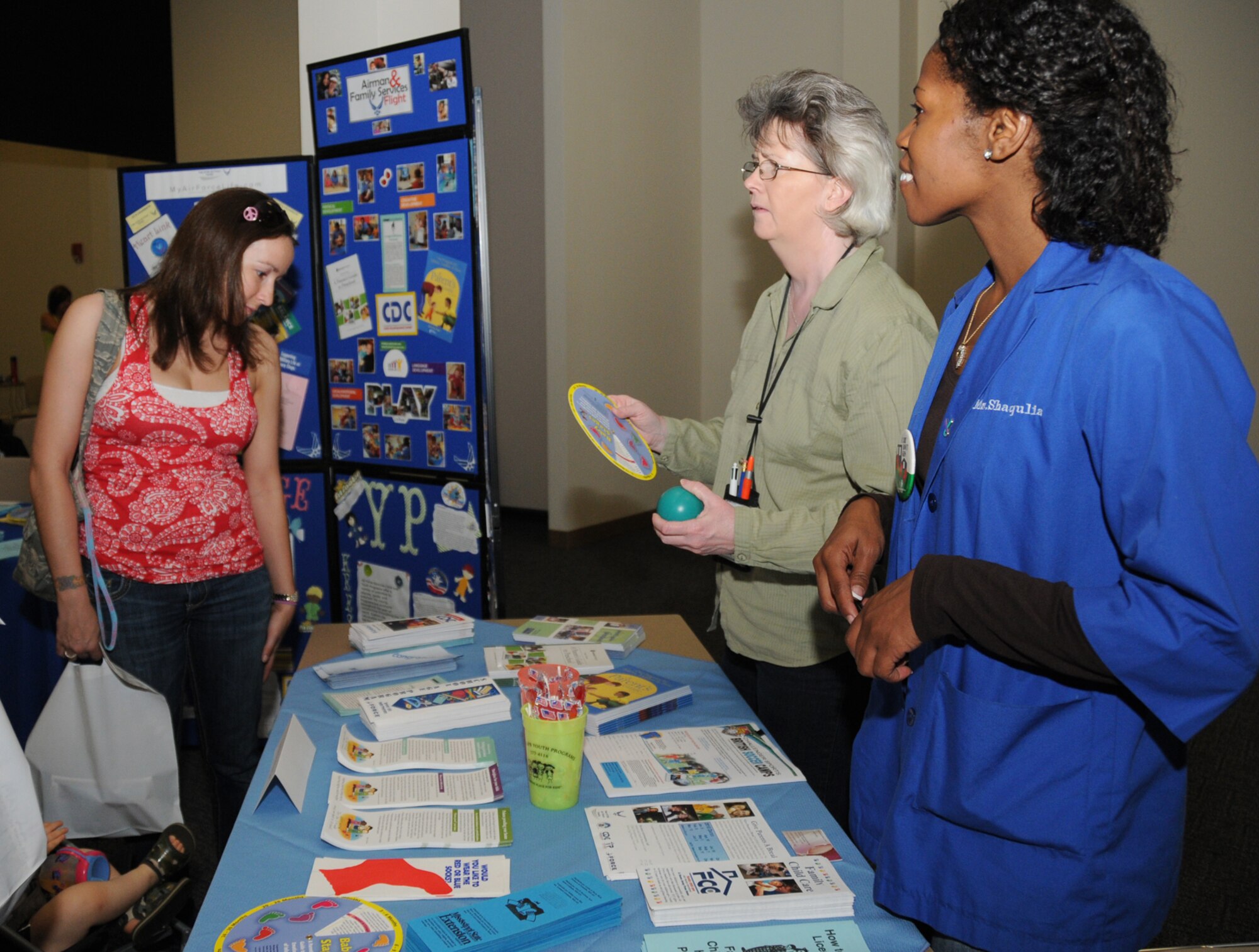 Linda Viglione, spouse of Staff Sgt. Jason Viglione, 338th Training Squadron, gets information on the child development center from CDC staff members Victoria Jones and Shaqulia Duckworth during Pamper Me Day, May 7 at the Roberts Consolidated Aircraft Maintenance Facility.  The annual event sponsored by the airman and family readiness center featured agencies, vendors, giveaways, activities, business and product displays and information booths.  (U.S. Air Force photo by Kemberly Groue)