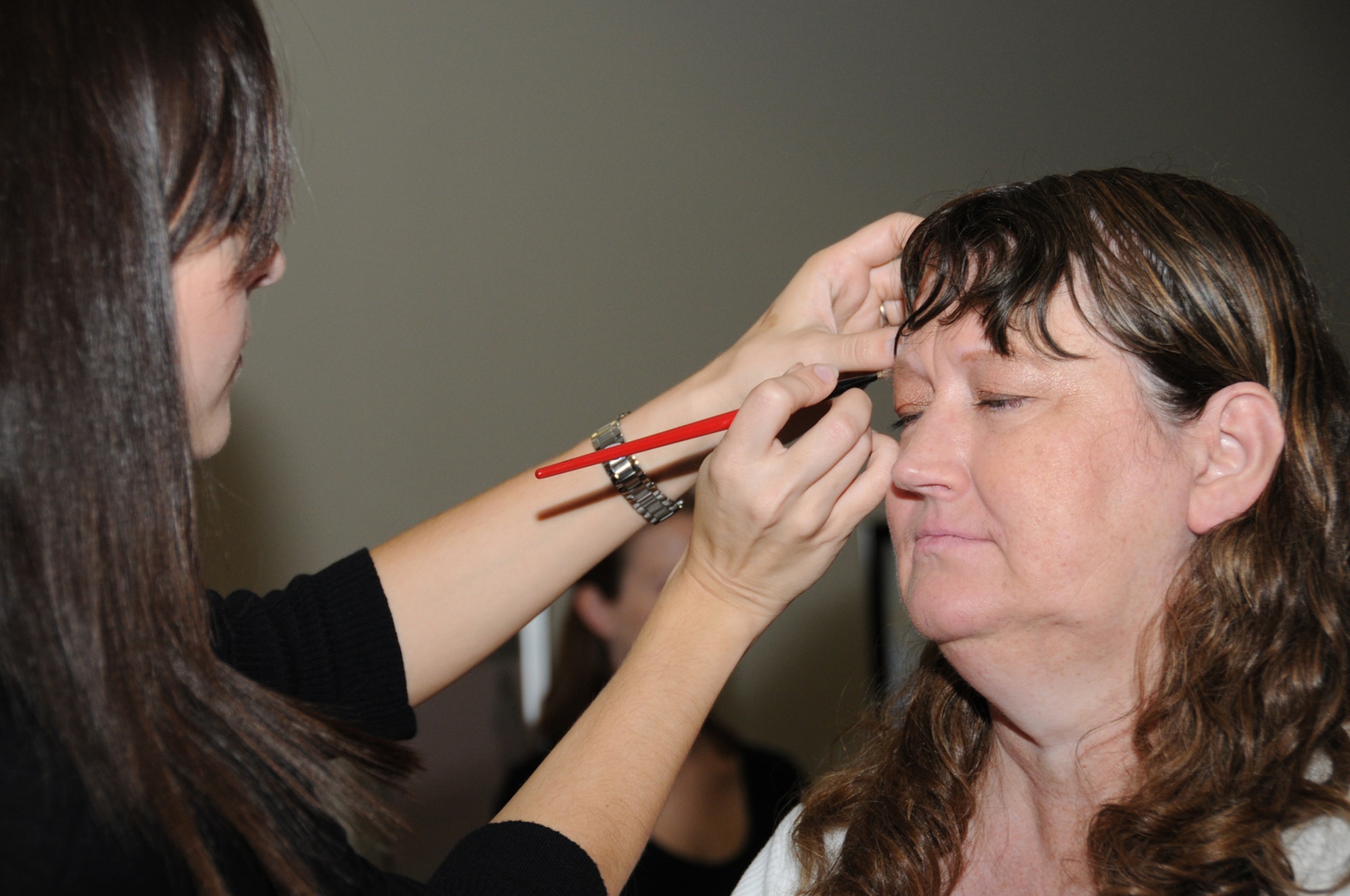 Sarah Deeds, left, a vendor from the base exchange, gives Brenda Rosipko a makeover during Pamper Me Day, May 7 at the Roberts Consolidated Aircraft Maintenance Facility.  The annual event sponsored by the airman and family readiness center featured agencies, vendors, giveaways, activities, business and product displays and information booths.  (U.S. Air Force photo by Kemberly Groue)