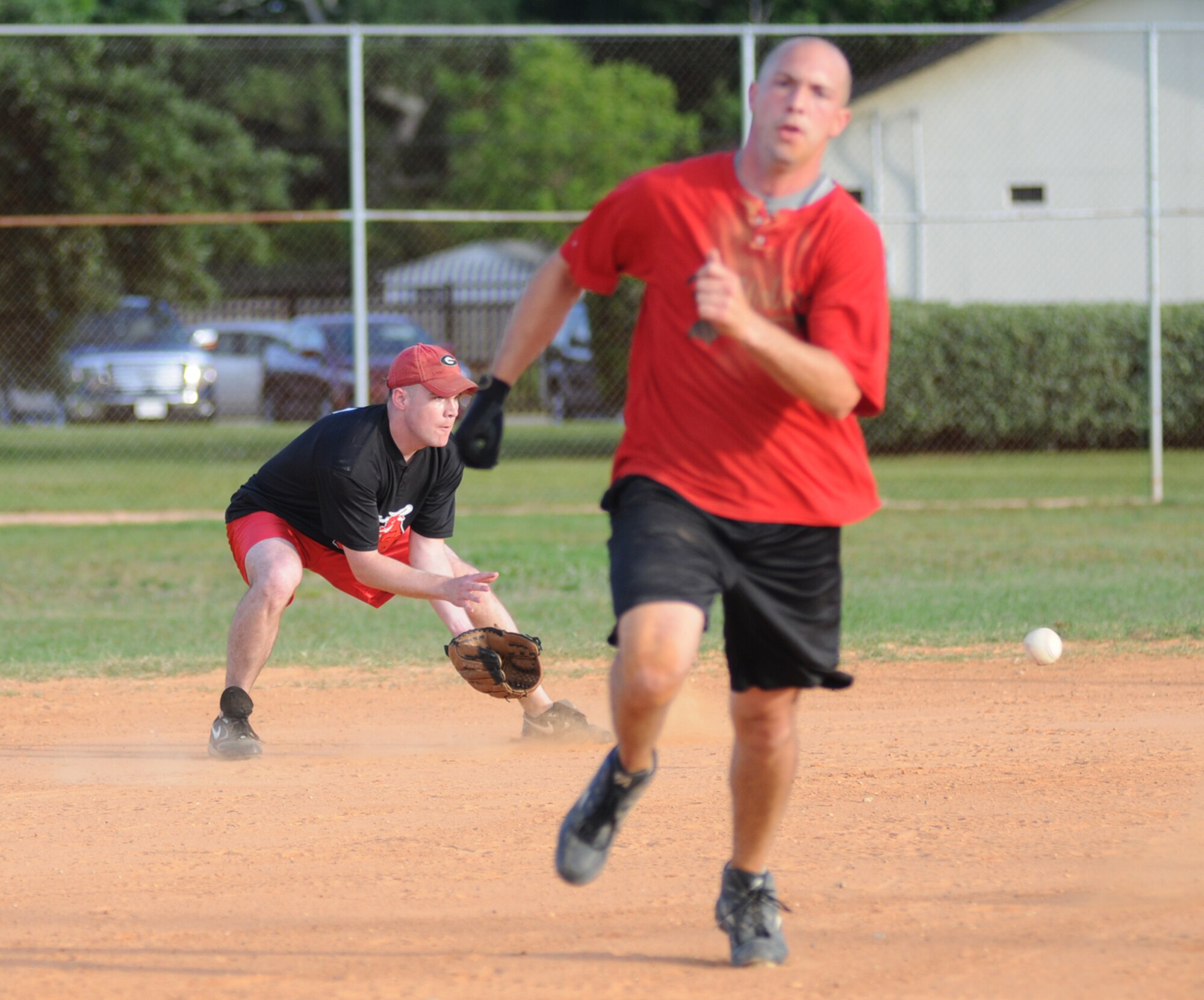 Shortstop Brent Bell, 335th TRS, waits for the ball to reach him as Jon McCullar, 336th TRS, takes off toward toward third base during an opening day game Monday at the Triangle Fields.  The 335th TRS claimed the win, 11-1.   (U.S. Air Force photo by Kemberly Groue)