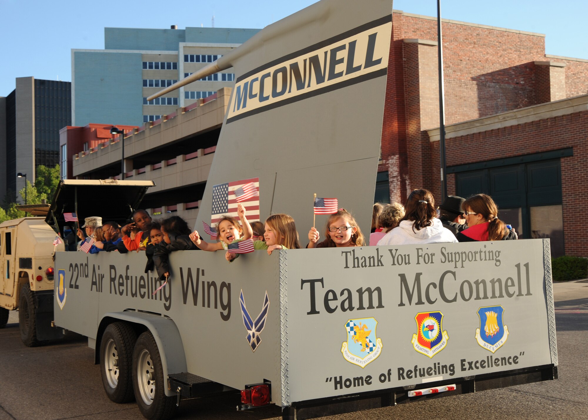McConnell family members ride a float created by Airmen of the 22nd Maintenance Squadron fabrication flight and the 22nd Operations Support Squadron, during the Sundowner Parade for Wichita’s River Festival May 7, 2010, downtown Wichita, Kan. The float construction was completed in time for the parade. For the past few years, McConnell’s float was usually a borrowed trailer that had to be taken apart every time before and after the parade happened. (U.S. Air Force photo/Airman 1st Class Andrea Salazar)