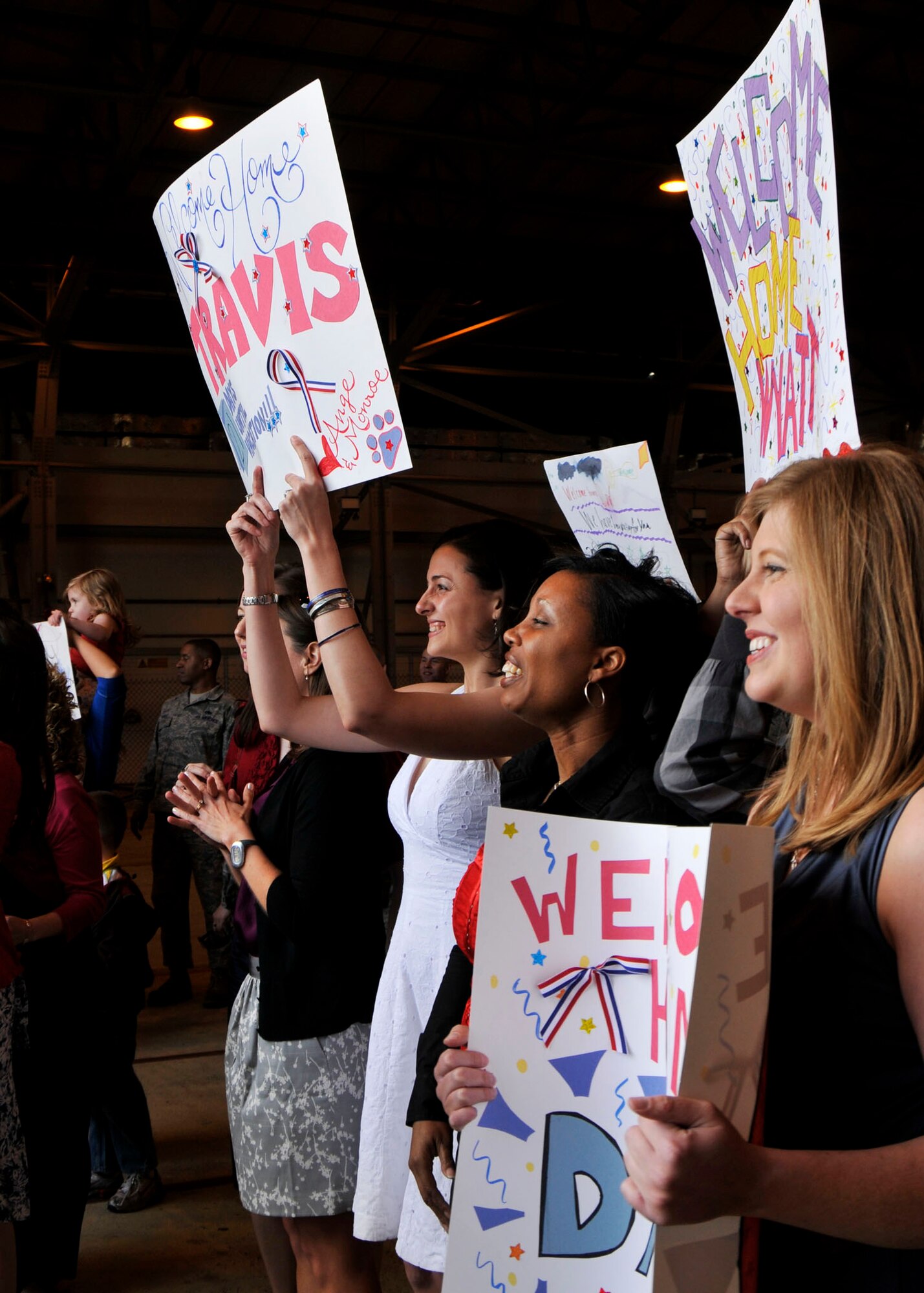 Family members wait with welcome signs for the returning deployers at Hangar 6 on May 6 at RAF Lakenheath. The deployers returned from a four-month deployment to Bagram Air Base, Iraq. (U.S. Air Force photo by Airman 1st Class Tiffany M. Deuel)