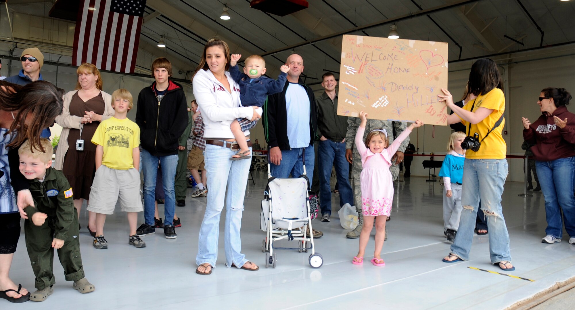 Friends and family members await the return of Cannon Airmen from overseas deployments at a hangar May 8. Operation Homecoming welcomed back Airmen from several squadrons with music and snacks. (U.S. Air Force Photo by Senior Airman Evelyn Chavez)