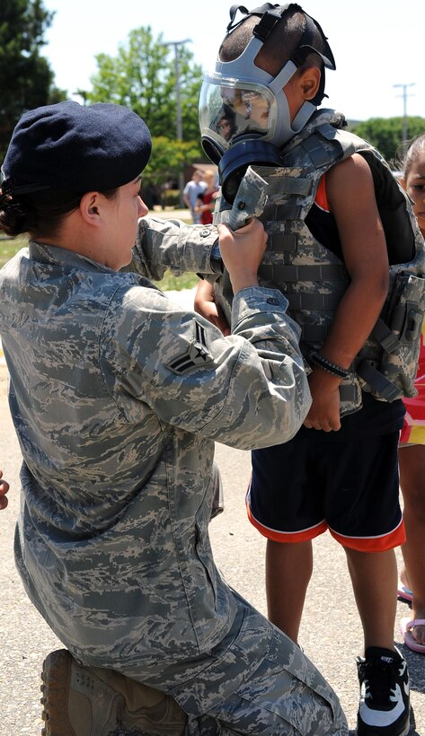 LANGLEY AIR FORCE BASE, Va. -- Airman 1st Class Amber Boyd, 633d Security Forces squadron installation entry controller, puts on a kevlar vest on her son Elijah Tidwell at the Base Exchange parking lot May 9. The display was part of the National Police Week celebration, paying tribute to law enforcement officers who lost their lives in the line of duty. (U.S. Air Force photo/Airman 1st Class Gul Crockett)