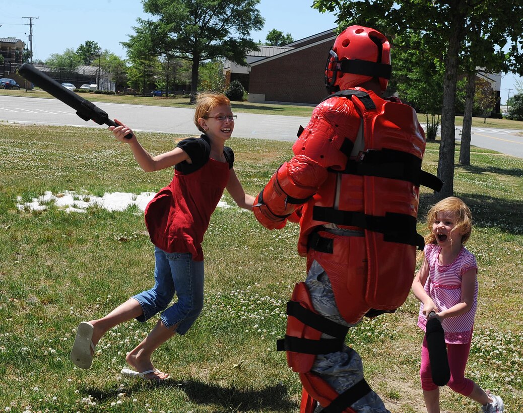 LANGLEY AIR FORCE BASE, Va. -- Staff Sgt. Jason Balcita, 633d Security Forces Squadron unit trainer, plays with Kayla and Abrianna Denisi at the Base Exchange parking lot May 9. The 633 SFS showcased its capabilities in a series of displays as part of the National Police Week celebration, paying tribute to law enforcement officers who lost their lives in the line of duty. (U.S. Air Force photo/Airman 1st Class Gul Crockett)