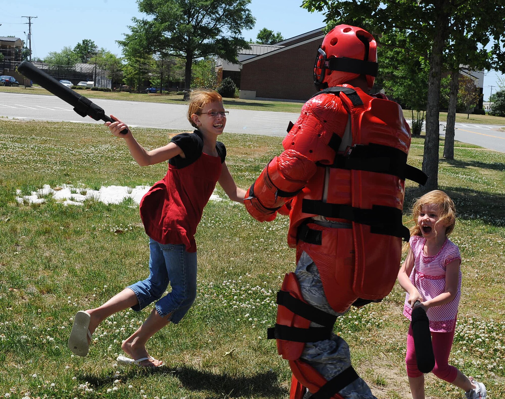 LANGLEY AIR FORCE BASE, Va. -- Staff Sgt. Jason Balcita, 633d Security Forces Squadron unit trainer, plays with Kayla and Abrianna Denisi at the Base Exchange parking lot May 9. The 633 SFS showcased its capabilities in a series of displays as part of the National Police Week celebration, paying tribute to law enforcement officers who lost their lives in the line of duty. (U.S. Air Force photo/Airman 1st Class Gul Crockett)