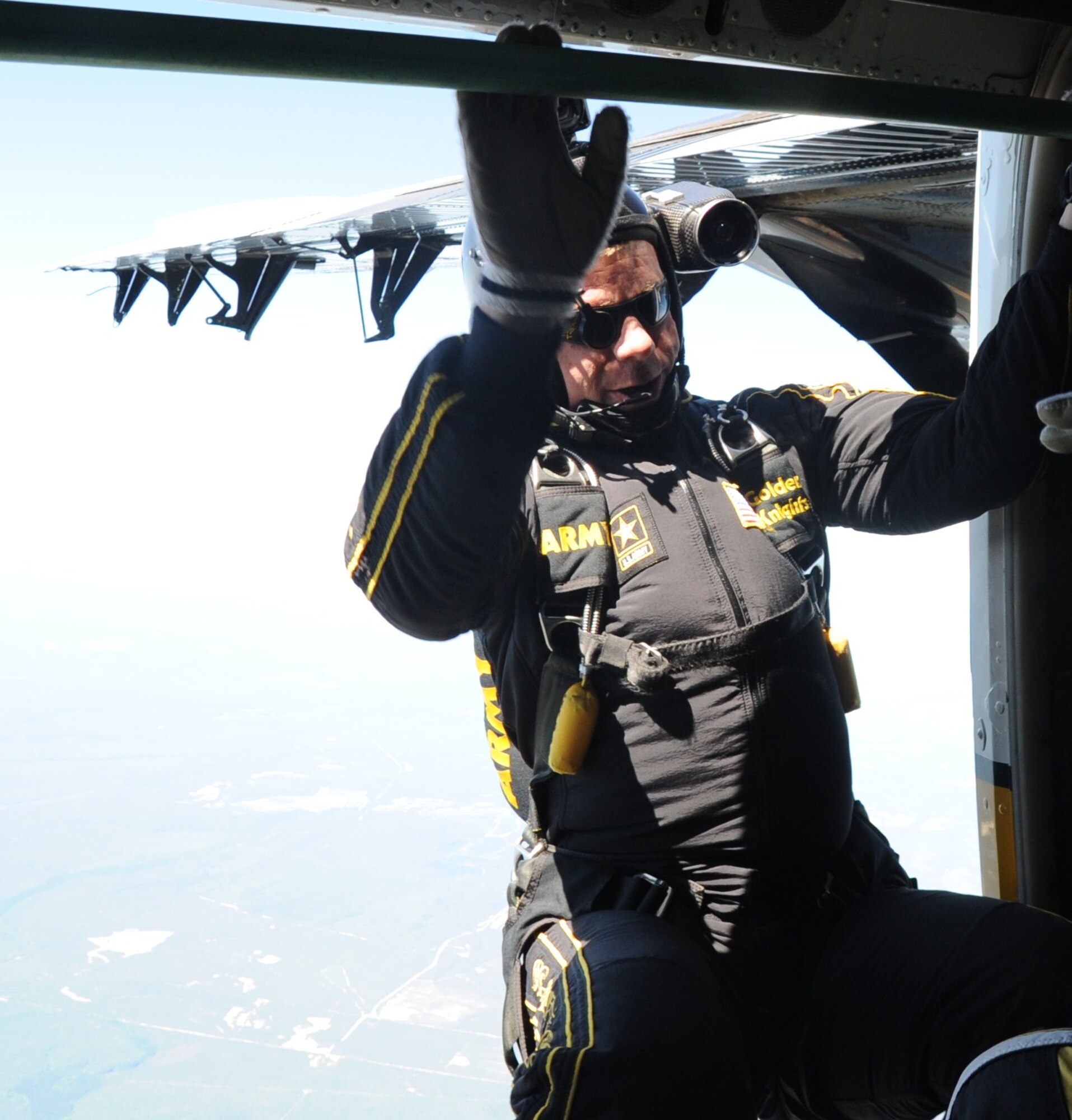 Army Sgt. Joseph Abeln, Golden Knights videographer, prepares to jump out of a plane backwards simultaneously with the tandem jumpers to ensure video footage. The Golden Knights' videographers attach cameras to their helmets to videotape the tandem freefalls and landings for guest jumpers. (U.S. Navy photo/Sherry Jacob)
