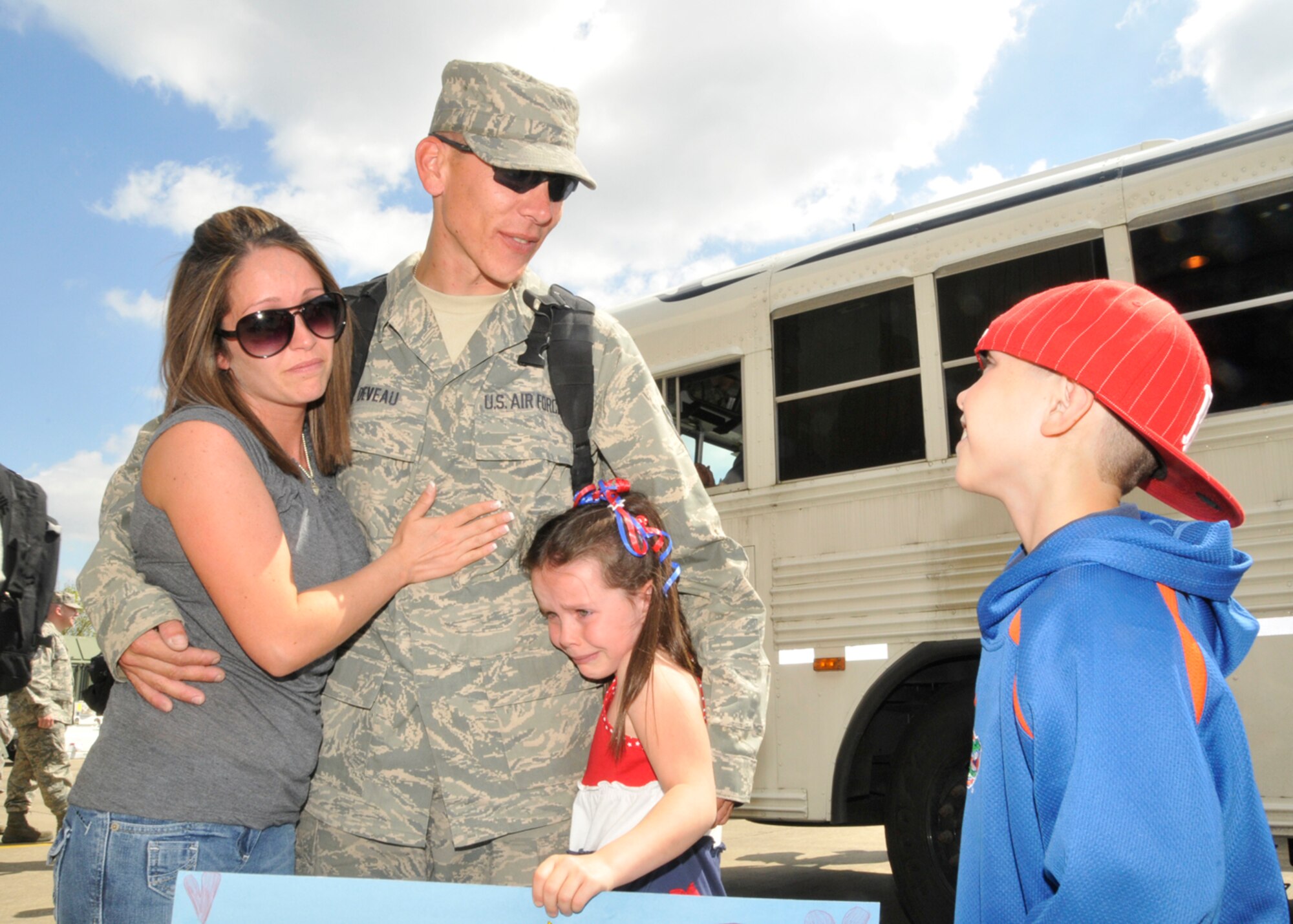 Staff Sgt.  Jason Deveau, 48th Component Maintenance Squadron jet engine mechanic craftsman, is hugged and greeted by his wife, Kristin, and children, Kayla, 6, and Tyler, 9, after arriving at Hangar Six at RAF Lakenheath, England, May 6. Sergeant Deveau was returning from a four-month deployment to Bagram Air Base, Afghanistan. (U.S. Air Force photo/Airman 1st Eboni Knox)