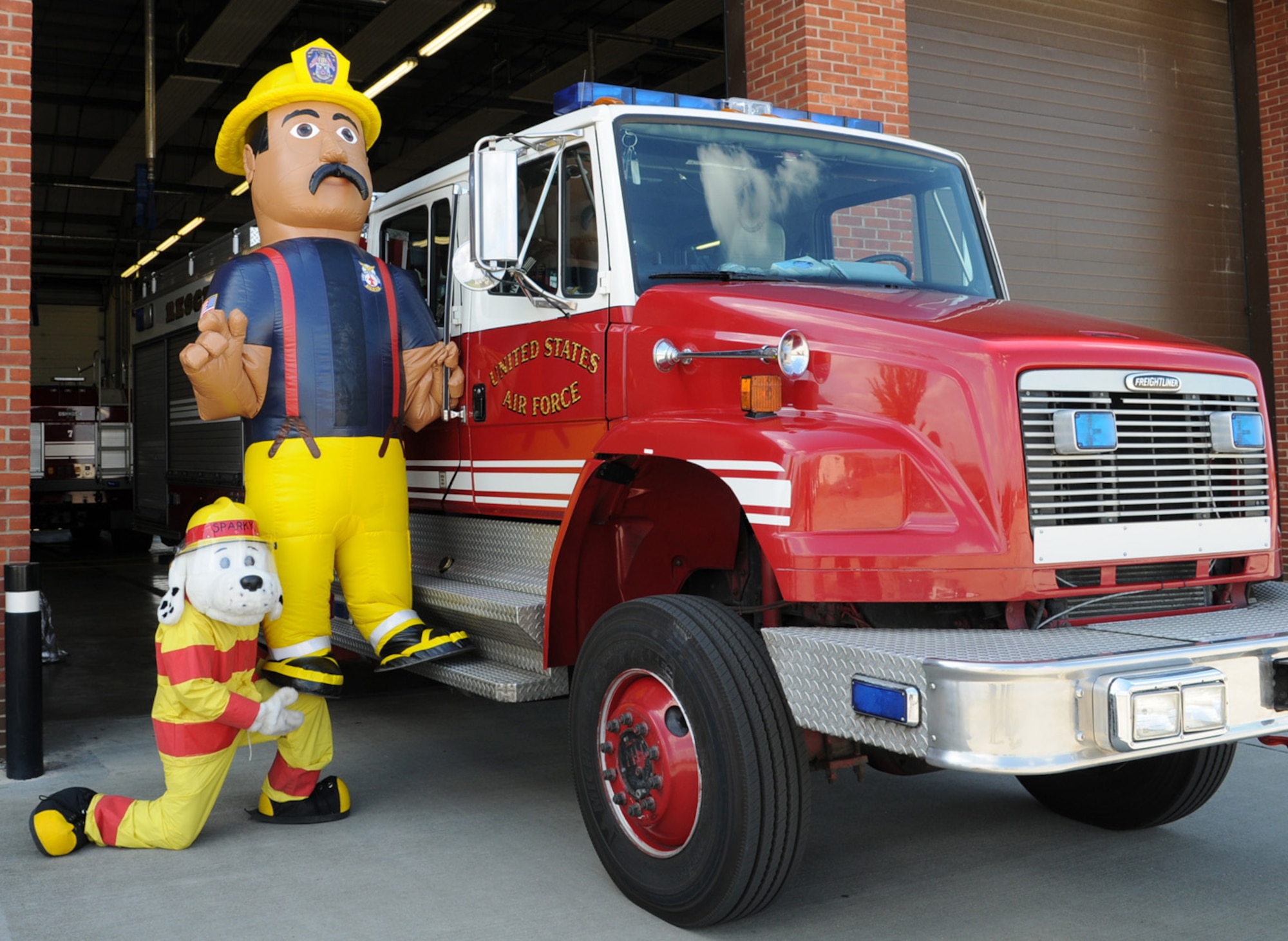 Sparky the Fire Dog shows off his strength as he lifts Firefighter Gary, the newest member of the 100th Civil Engineer Squadron Fire Department, up onto the step of Rescue 3. Gary is part of the fire prevention team and will visit events with Sparky and his firefighter friends, to spread the message about fire prevention.  (U.S. Air Force photo by Karen Abeyasekere)