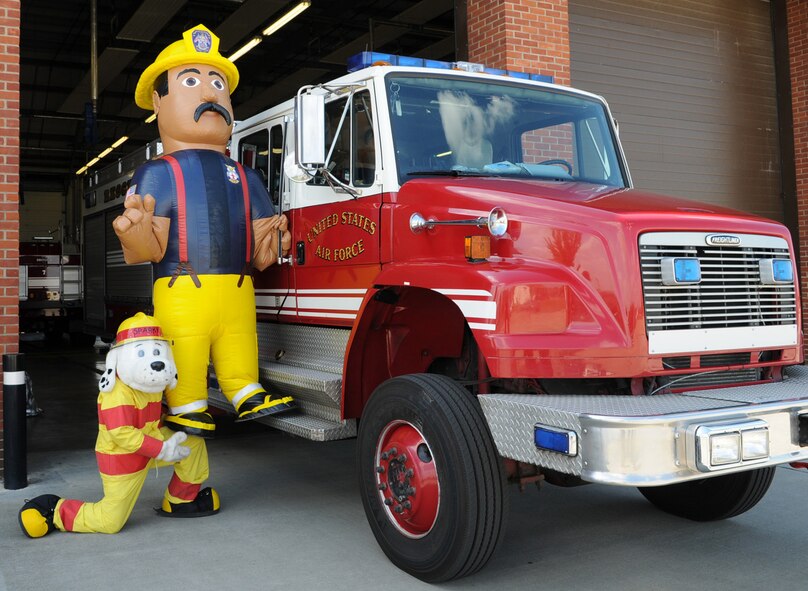 Sparky the Fire Dog shows off his strength as he lifts Firefighter Gary, the newest member of the 100th Civil Engineer Squadron Fire Department, up onto the step of Rescue 3. Gary is part of the fire prevention team and will visit events with Sparky and his firefighter friends, to spread the message about fire prevention.  (U.S. Air Force photo by Karen Abeyasekere)