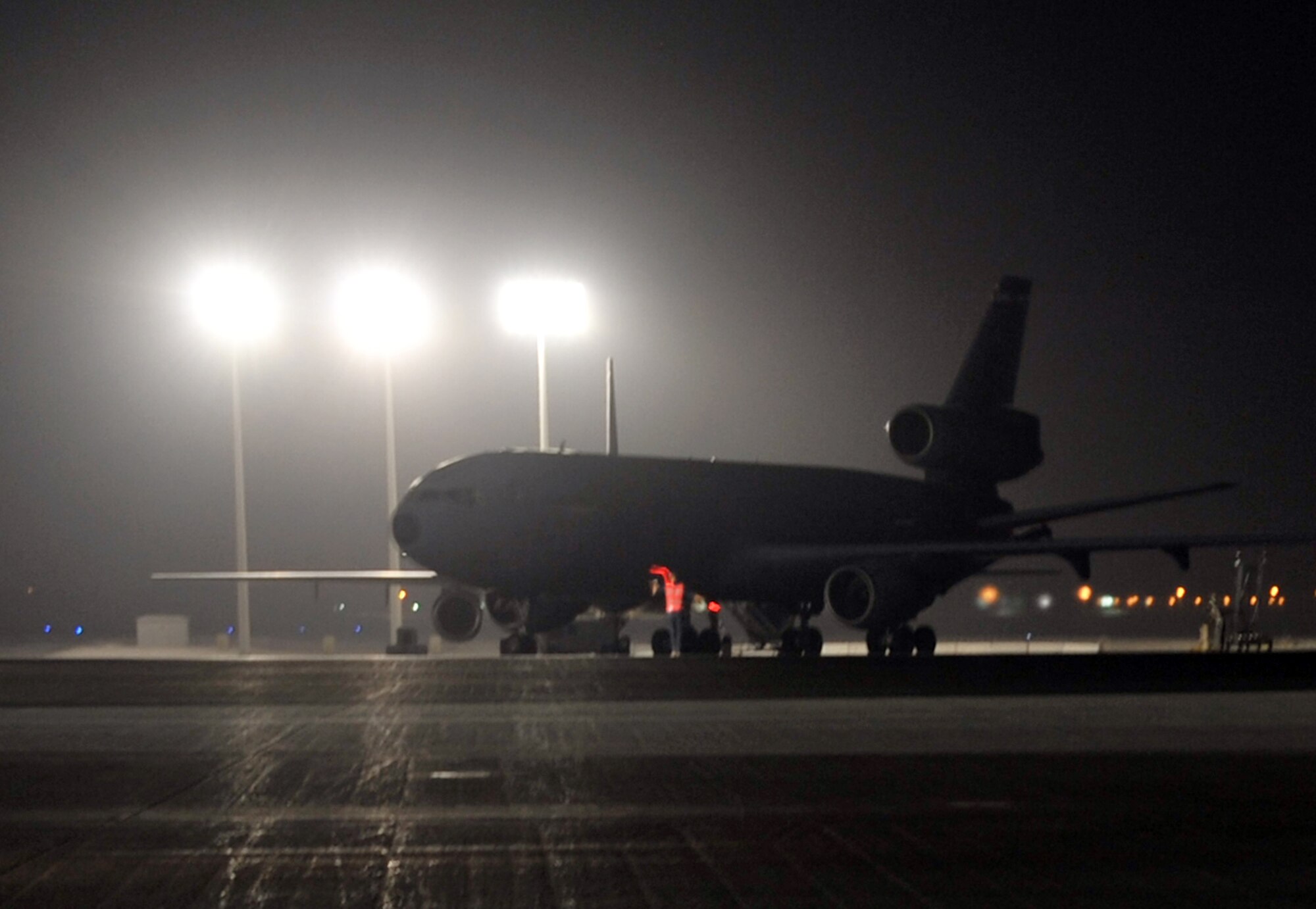 A KC-10 Extender maintenance Airman from the 380th Expeditionary Aircraft Maintenance Squadron Extender aircraft maintenance unit uses light sticks to help guide aircrew members driving a KC-10 for a mission April 30, 2010, at a non-disclosed base in Southwest Asia. The 380th EAMXS, as part of the 380th Air Expeditionary Wing, supports operations Iraqi Freedom and Enduring Freedom and the Combined Joint Task Force-Horn of Africa. (U.S. Air Force Photo/Master Sgt. Scott T. Sturkol/Released)