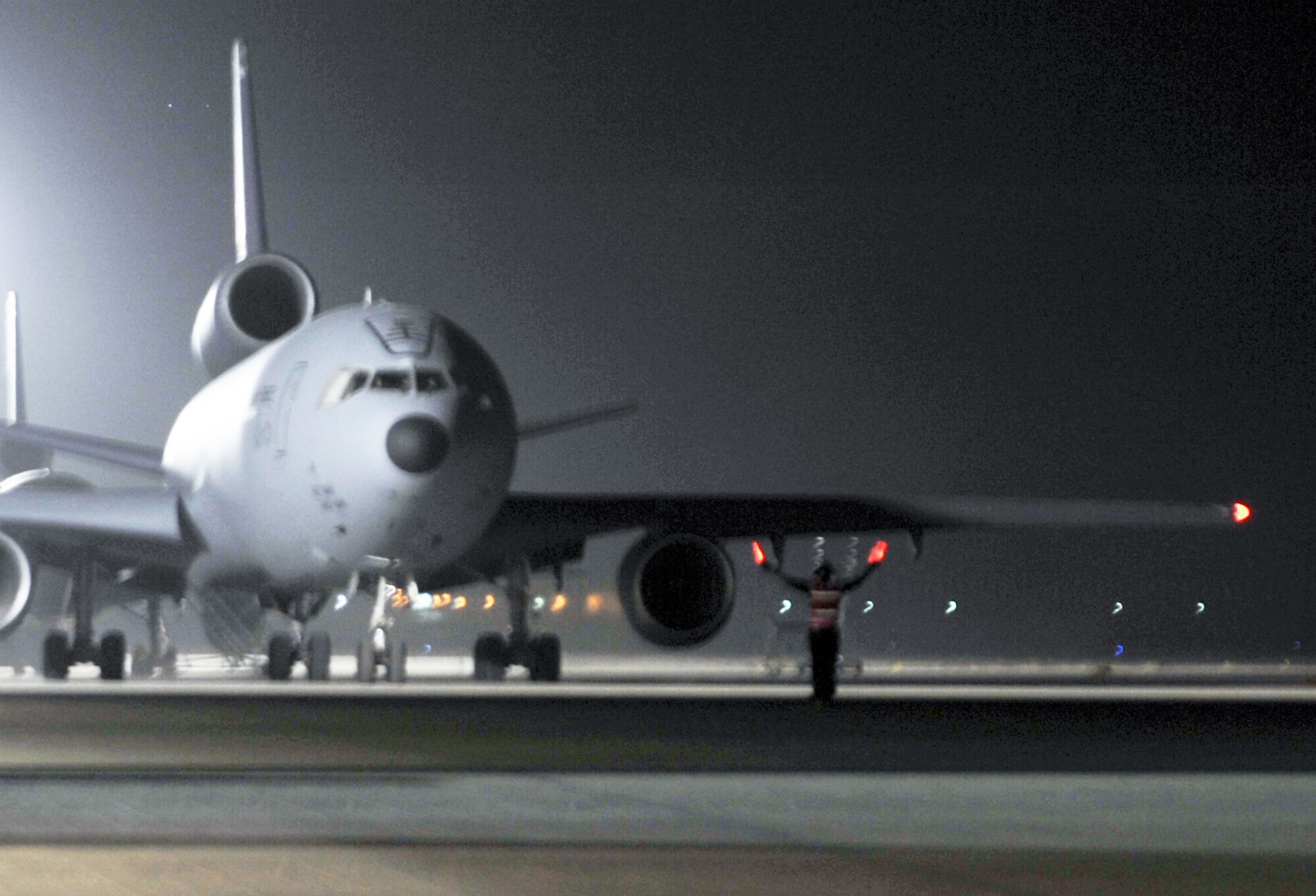 A KC-10 Extender maintenance Airman from the 380th Expeditionary Aircraft Maintenance Squadron Extender aircraft maintenance unit uses light sticks to help guide aircrew members driving a KC-10 for a mission April 30, 2010, at a non-disclosed base in Southwest Asia. The 380th EAMXS, as part of the 380th Air Expeditionary Wing, supports operations Iraqi Freedom and Enduring Freedom and the Combined Joint Task Force-Horn of Africa. (U.S. Air Force Photo/Master Sgt. Scott T. Sturkol/Released)