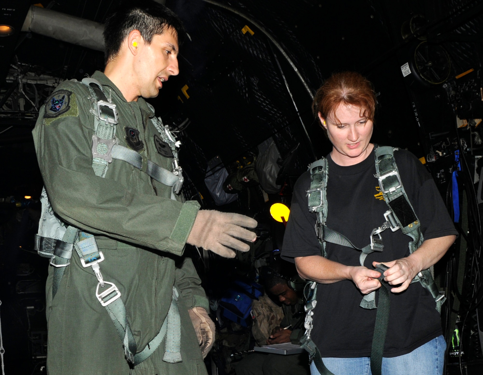 KADENA AIR BASE, Japan -- Staff Sgt. Andy Strause, a 17th Special Operations Squadron loadmaster, instructs Tina Anderson on how to properly wear a harness in the back of a MC-130P Combat Shadow here May 7 during a spouse orientation flight. Spouses from the 353rd Special Operations Group were treated to a small capabilities brief, a tour of the 320th Special Tactics Squadron and their equipment and orientation flights during a spouse orientation day. (U.S. Air Force photo by Tech. Sgt. Chrissy Best)