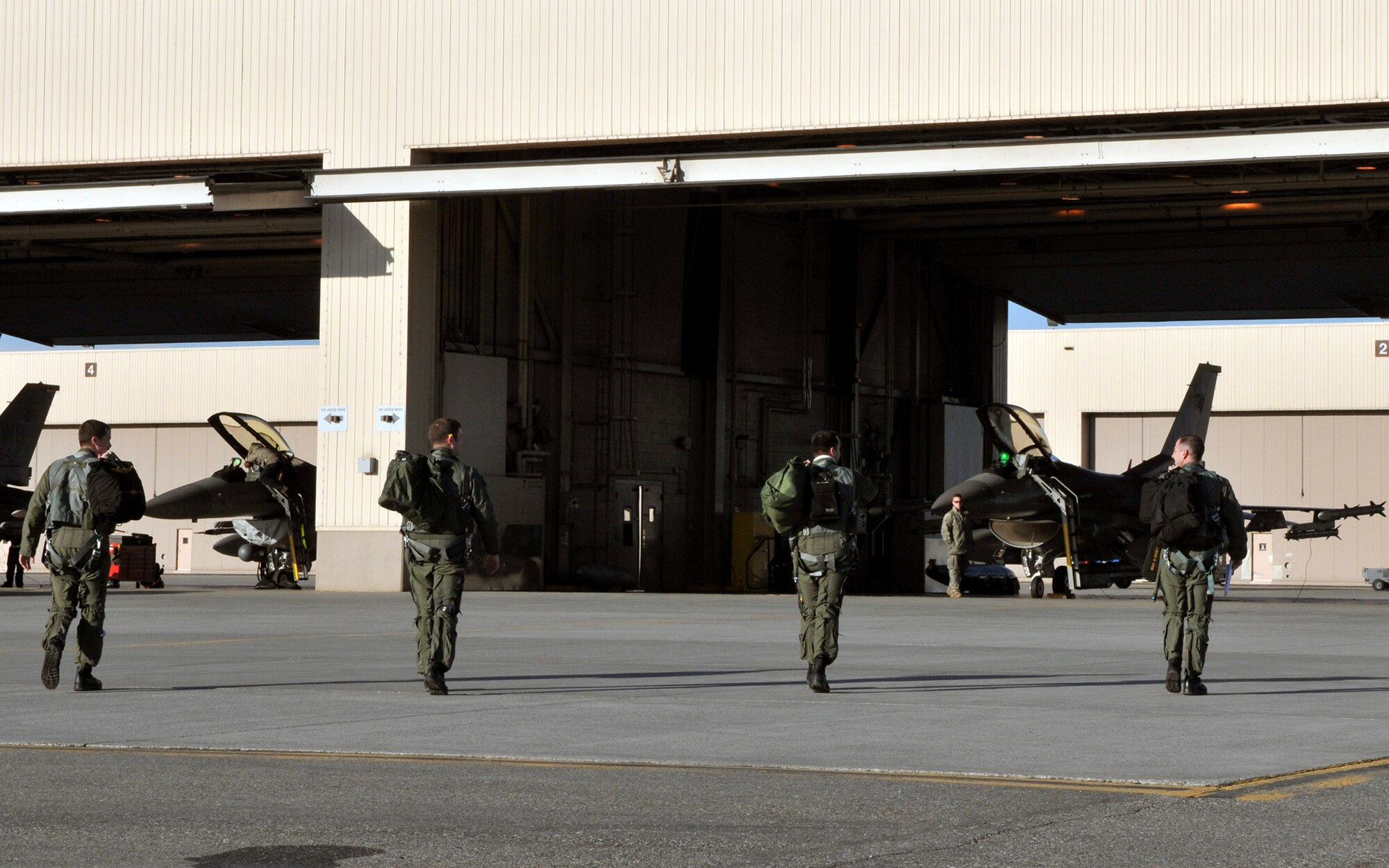 Pilots with the 80th Fighter Squadron Headhunters, known as the "Juvats," step to their F-16 Fighting Falcons before a mission during Red Flag-Alaska April 21. The Airmen are deployed from the 8th Fighter Wing, Kunsan Air Base, Republic of Korea. Red Flag-Alaska is a field training exercise that provides joint offensive counter-air, interdiction, close air support, and large force employment training in a simulated combat environment. (U.S. Air Force photo/Capt. Shannon Collins)