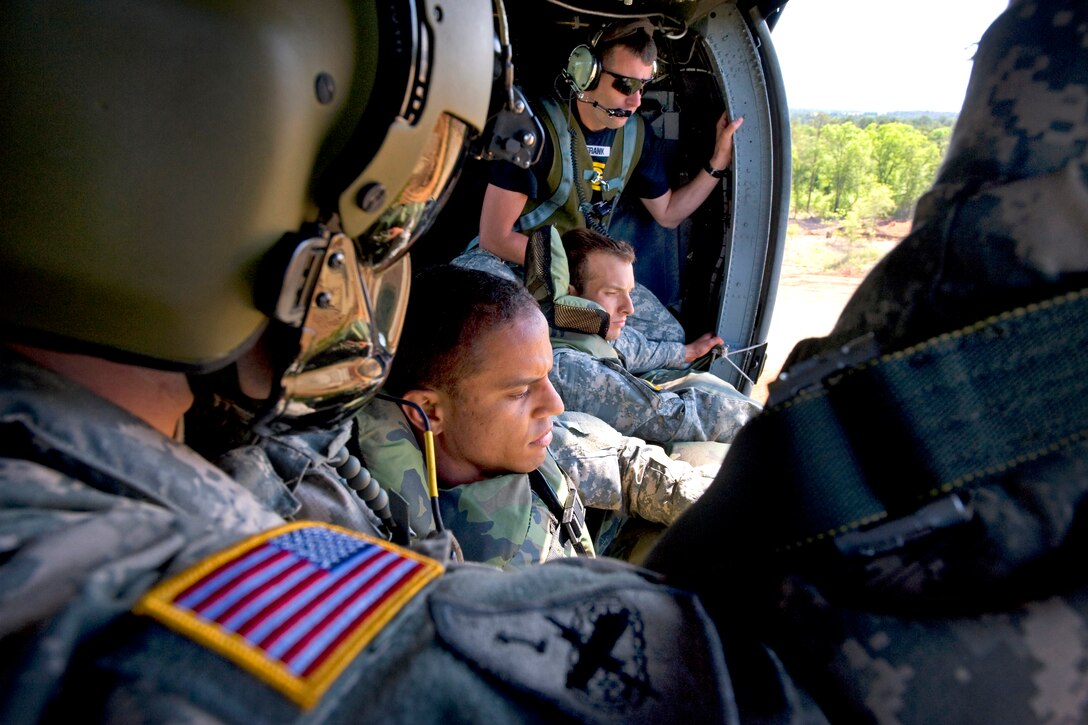 U.S. Army Spc. Cristobal Cruz and Staff Sgt. Wilton Gleaton ready themselves for an air assault drop during the 27th Annual Best Ranger Competition over Freedom Pond, Fort. Benning, Ga., May 9, 2010. Cruz and Gleaton are assigned to the 75th Ranger Regiment. During this phase teams were required to construct a poncho raft and swim following a 100+ drop.