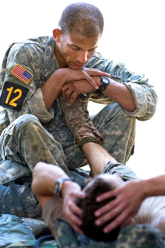 U.S. Army Staff Sgt. Bernado Mota helps his teammate Staff Sgt. Jeremiah Waggoner, stretch out severe cramping in both legs after calling for an IV following an event in the 2010 Best Ranger Competition, Camp Darby, Fort Benning, Ga., May 07, 2010. Mota and Waggoner, assigned to the 82nd Airborne Division, were unable to continue the competition due to injuries.