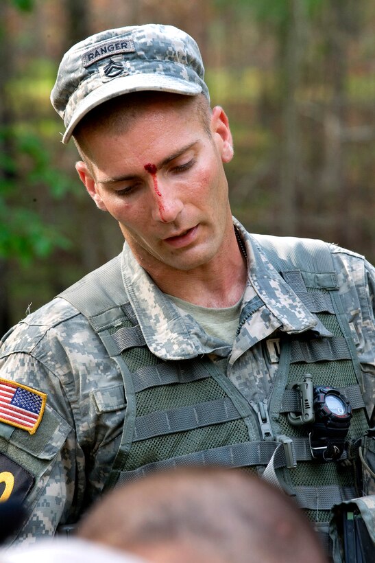 U.S. Army Staff Sgt. Michael Ayotte listens to an evaluation of his performance during the Ranger First Responder drill on the second day of the 2010 Best Ranger Competition, Camp Darby, Fort Benning, Ga., May 08, 2010. Ayotte is assigned to the 
6th Ranger Training Battalion. Ayottes focus was so intense; he didn't even notice the cut between his eyes.