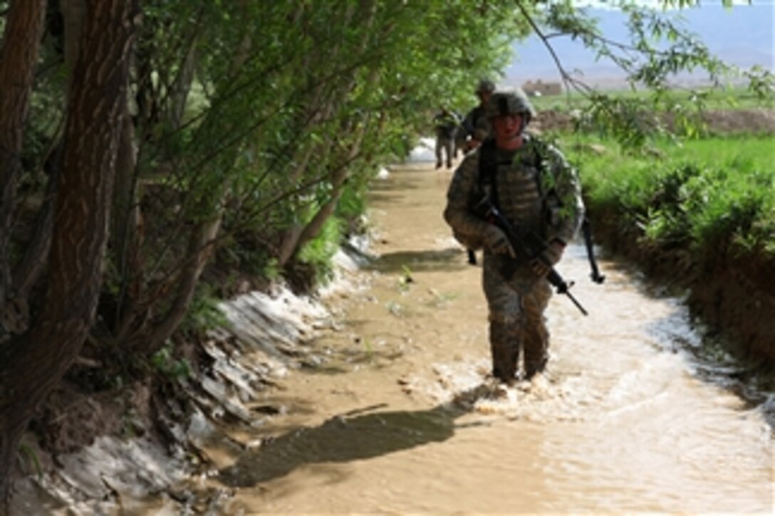 U.S. Army soldiers conduct a dismounted patrol through a creek in the village of Babus in the Pol-e’Alam district of Afghanistan on May 7, 2010.  