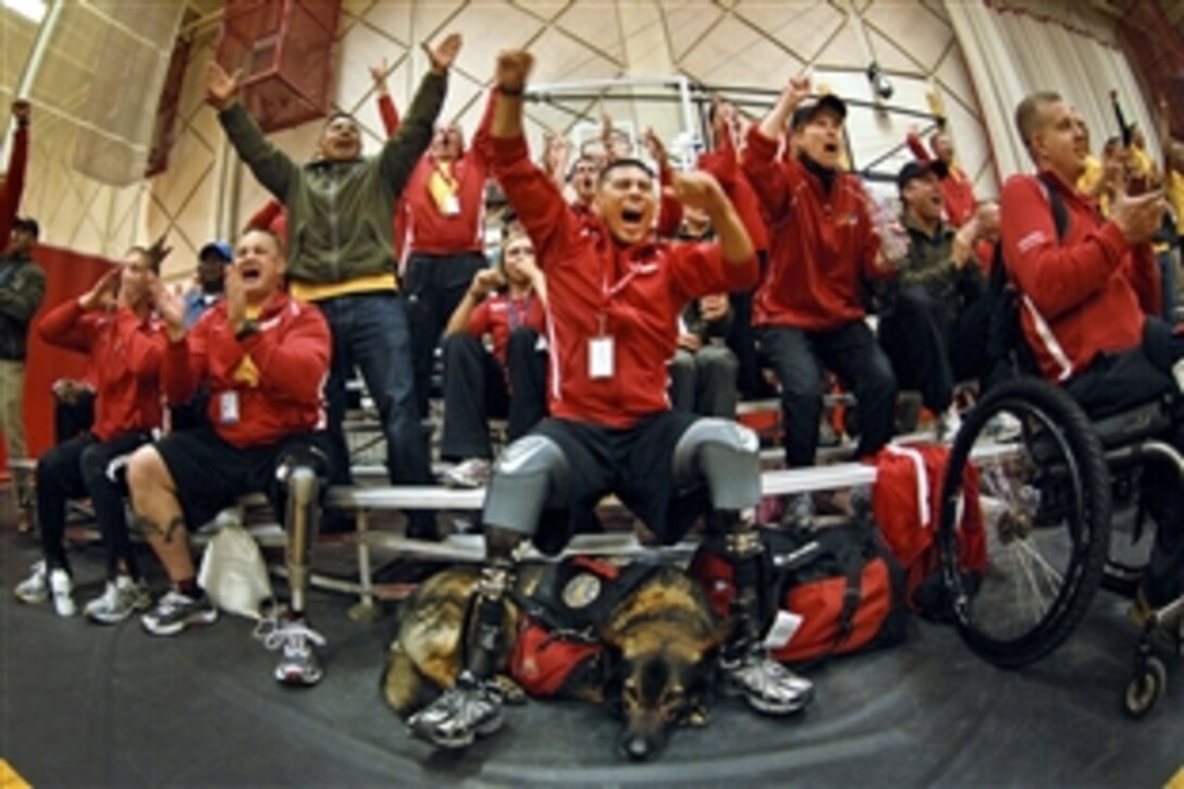 Marine Gunnery Sgt. Angel Barcenas and fellow Marines cheer on their teammates in the sitting volleyball game during the inaugural Warrior Games at the Olympic Training Facility, Colorado Springs, Colo., May 11, 2010. The Marines went on to win a nail-biter over Army 30 to 28. 