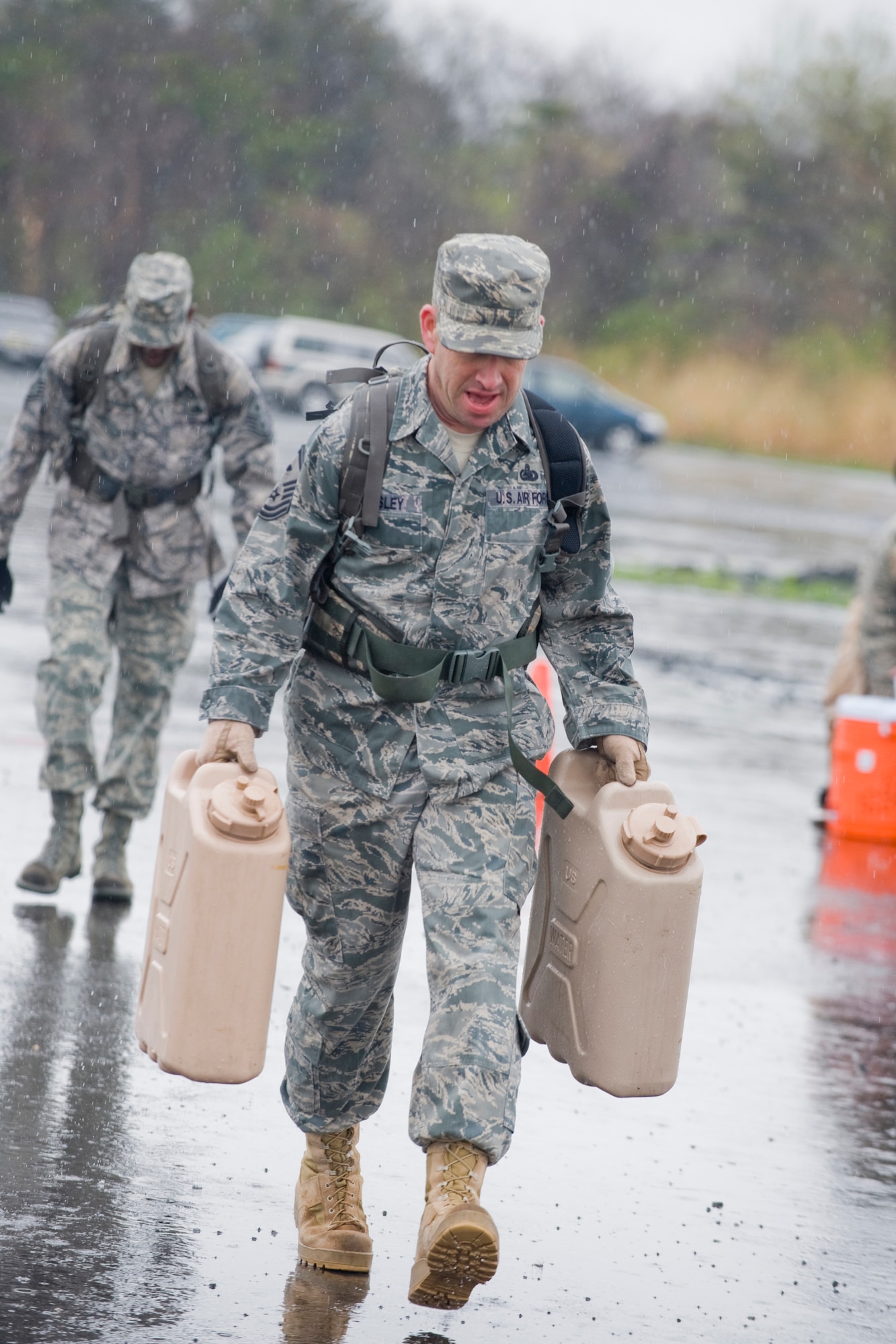 MISAWA AIR BASE, Japan -- Master Sgt. Jason Beardsley, 35th Security Forces Squadron first sergeant, carries canisters of water during an Air-Base Defense Challenge May 12 at Security Hill. The entire competition took place in the rain and physically tested its competitors while promoting stronger relationships between the 35th Security Forces Squadron and Navy Information Operations Command. (U.S. Air Force photo/Senior Airman Jamal D. Sutter)