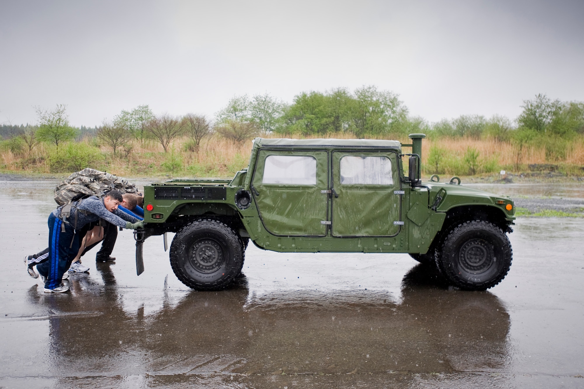 MISAWA AIR BASE, Japan -- Members of the Navy Information Operations Command Misawa push a humvee during an Air-Base Defense Challenge May 12 at Security Hill. The Navy team competed against three teams from the 35th Security Forces Squadron. (U.S. Air Force photo/Senior Airman Jamal D. Sutter)