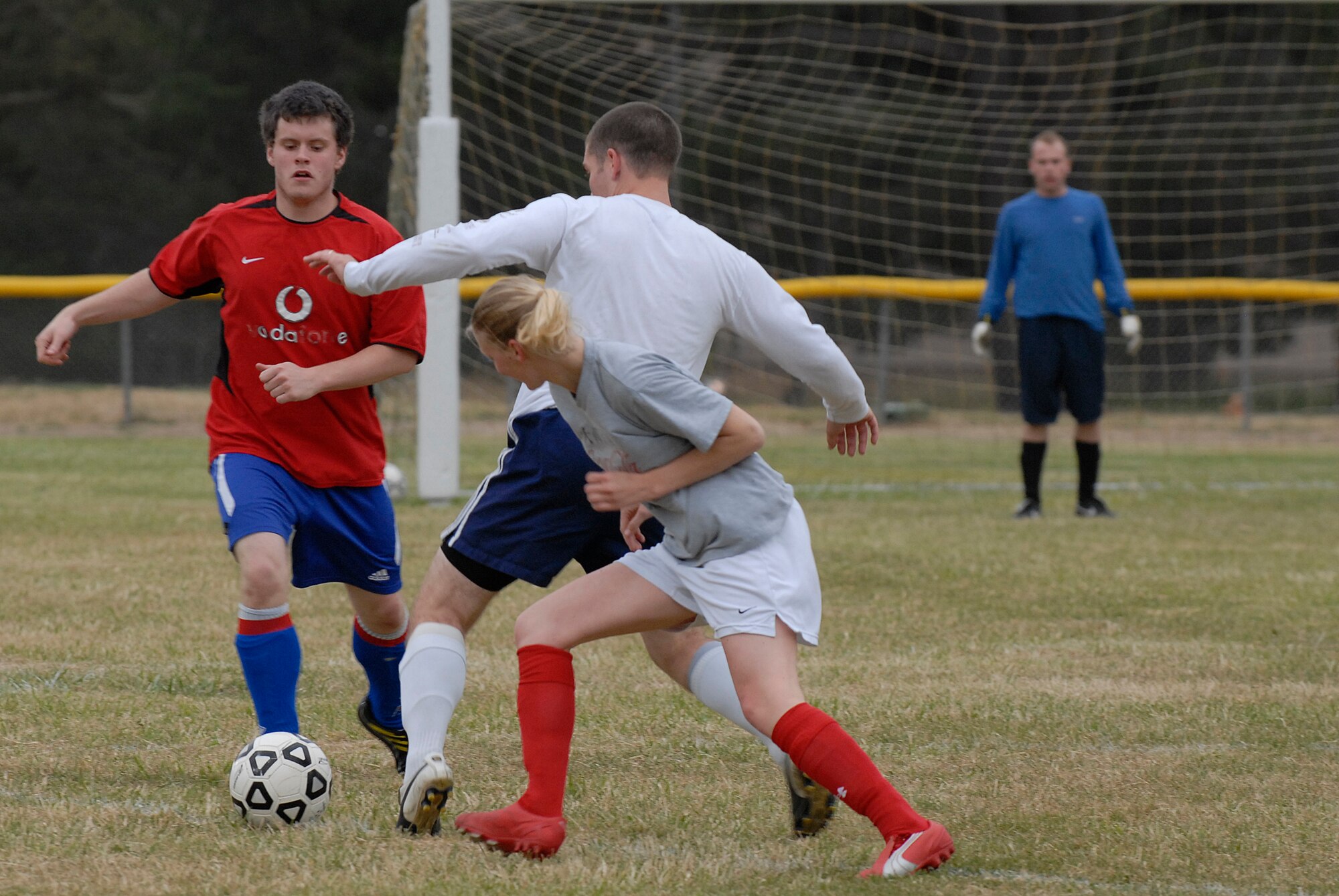 VANDENBERG AIR FORCE BASE, Calif. -- Frank Bocchino and Ashley Reed, 30th Space Communications Squadron team members, surround Dan Mortenson, a 30th Launch Group team member, to gain possession of the ball during an intramural soccer game at the base field here Wednesday, May 12, 2010.  The 30th Launch Group's defense shut out the 30th SCS team 9-0.  (U.S. Air Force photo/Senior Airman Andrew Satran) 

 

 

