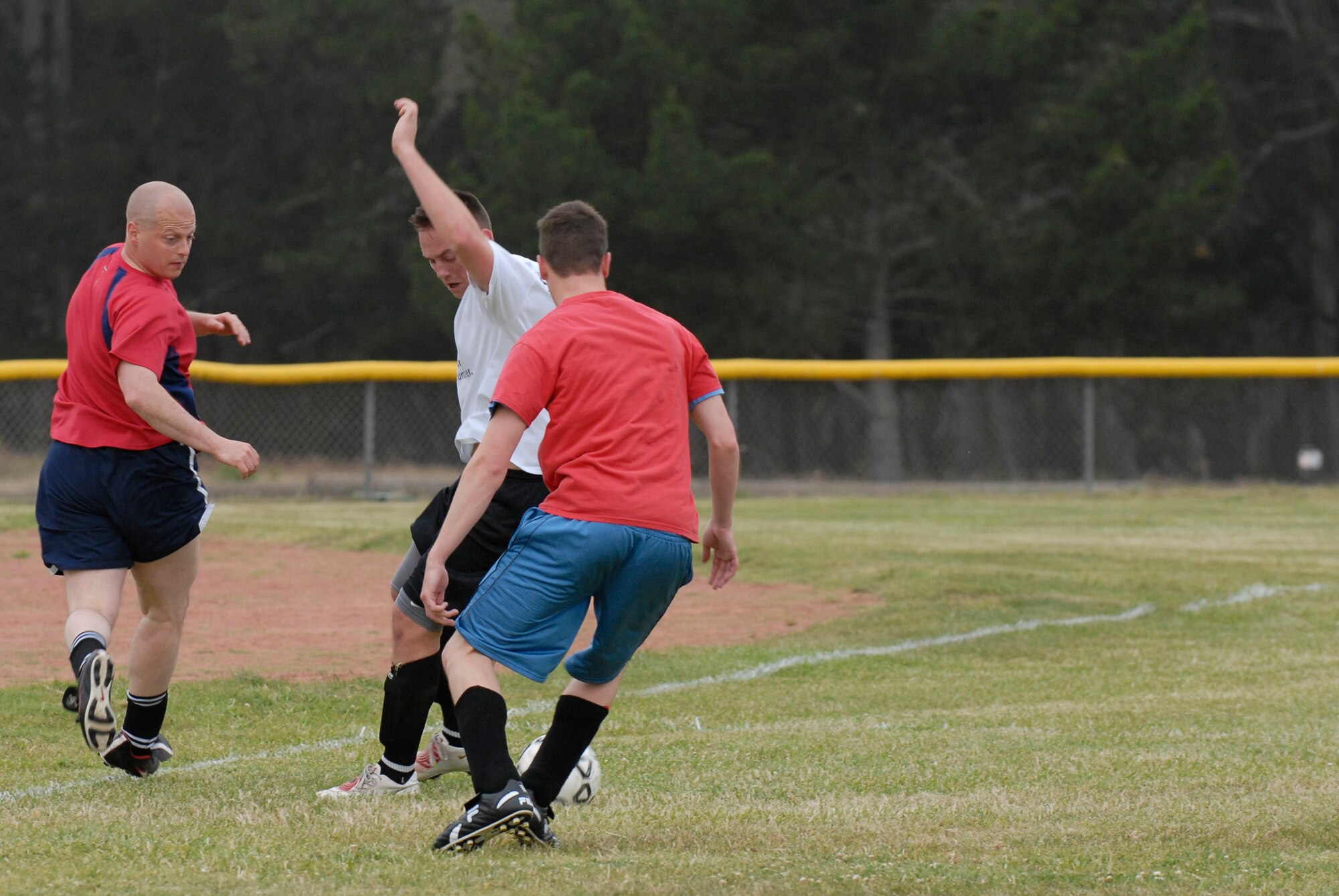 VANDENBERG AIR FORCE BASE, Calif. -- Michael Dombrowski and Brandon Satre, 30th Space Communications Squadron team members, surround Will Davis, a 30th Launch Group team member, to gain possession of the ball during an intramural soccer game at the base field here Wednesday, May 12, 2010.  The 30th Launch Group's defense shut out the 30th SCS team 9-0.  (U.S. Air Force photo/Senior Airman Andrew Satran) 

 
