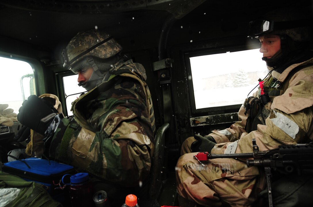 ELLSWORTH AIR FORCE BASE, S.D. – (Left to right) Airman Clarence Jones and Senior Airman Bryan McClellan, 28 Security Forces Squadron patrolmen, both warm up inside a Humvee during a Phase II Operational Readiness Exercise, May 12.  During the Phase II ORE, which was designed to test the ability to operate in a deployed environment, Airmen took the necessary precautions to stay warm during the spring snowfall. (U.S. Air Force photo/Airman 1st Class Anthony Sanchelli) 