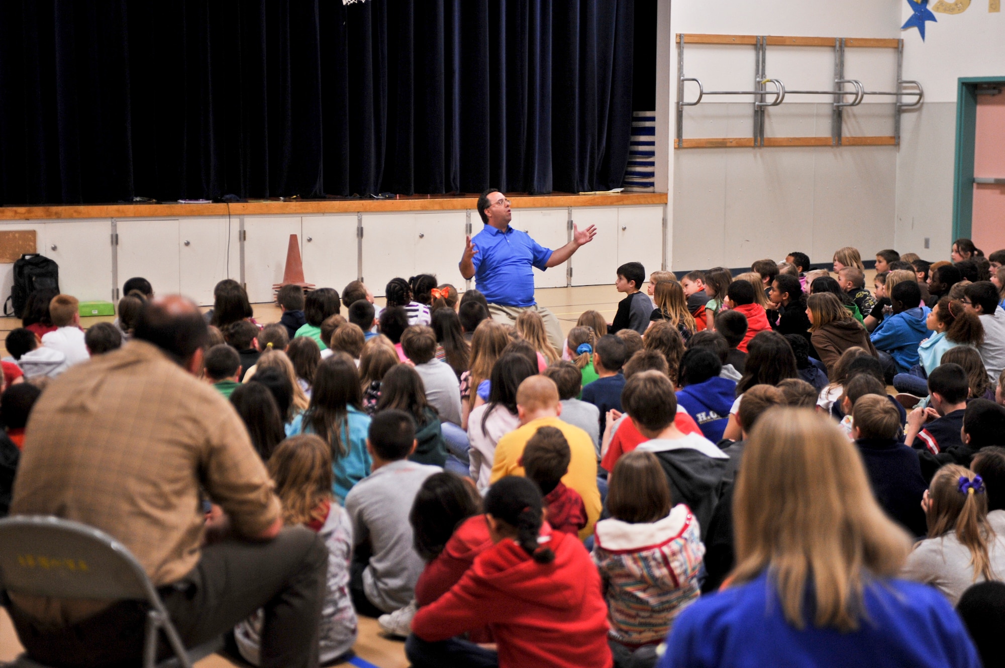ELMENDORF AIR FORCE BASE, Alaska – Sam Renick reads a chapter from his children’s book, “It’s a Habit Sammy the Rabbit,” by memory, to gymnasium full of Aurora Elementary School children May 12. Mr. Renick has traveled the globe with his pal Sammy the Rabbit, teaching children it’s important to save money through his books and songs. During his first trip to Alaska, Mr. Renick visited all three Elmendorf Elementary Schools. (Air Force photo by Airman 1st Class Christopher Gross)