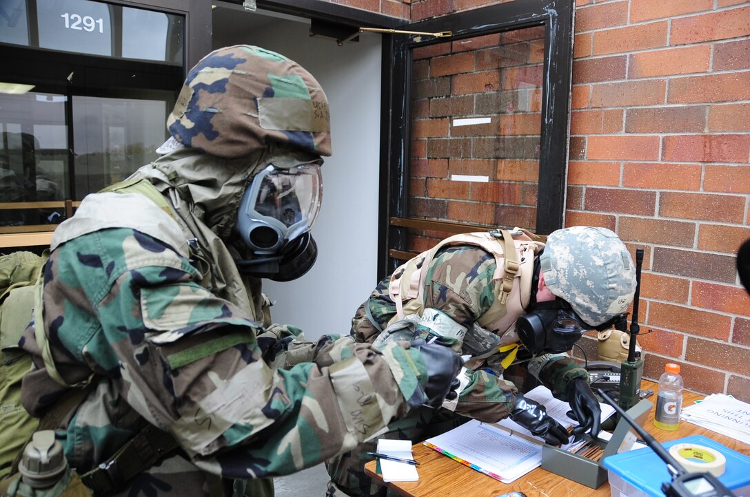 ELLSWORTH AIR FORCE BASE, S.D. -- (Left) Senior Airman David Brock, 28th Security Forces Squadron Airman, checks identification on Senior Airman John Shauri, 28th Mission Support Group client system technician, during a Phase II Operational Readiness Exercise while in mission oriented protective posture gear, May 11.  The Phase II ORE tests Airmen on their skills and abilities while under the stress of a simulated deployment. (U.S. Air Force photo/Airman 1st Class Anthony Sanchelli)